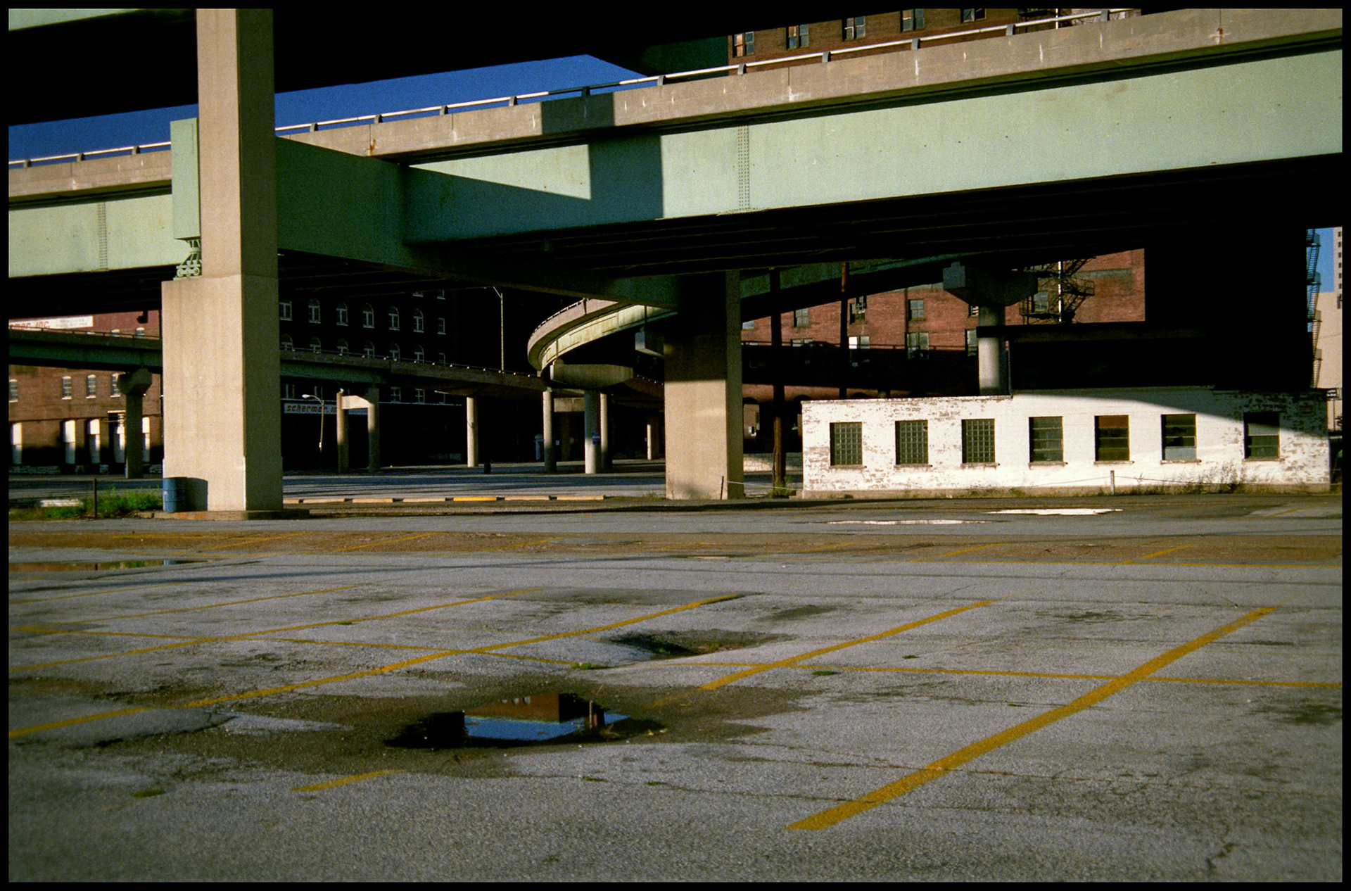 An empty parking lot underneath an overpass in downtown St. Louis. Part of a series shot one warm afternoon in November, 1988 called An Afternoon in St. Louis (a subset of my Industrial Geometry series).