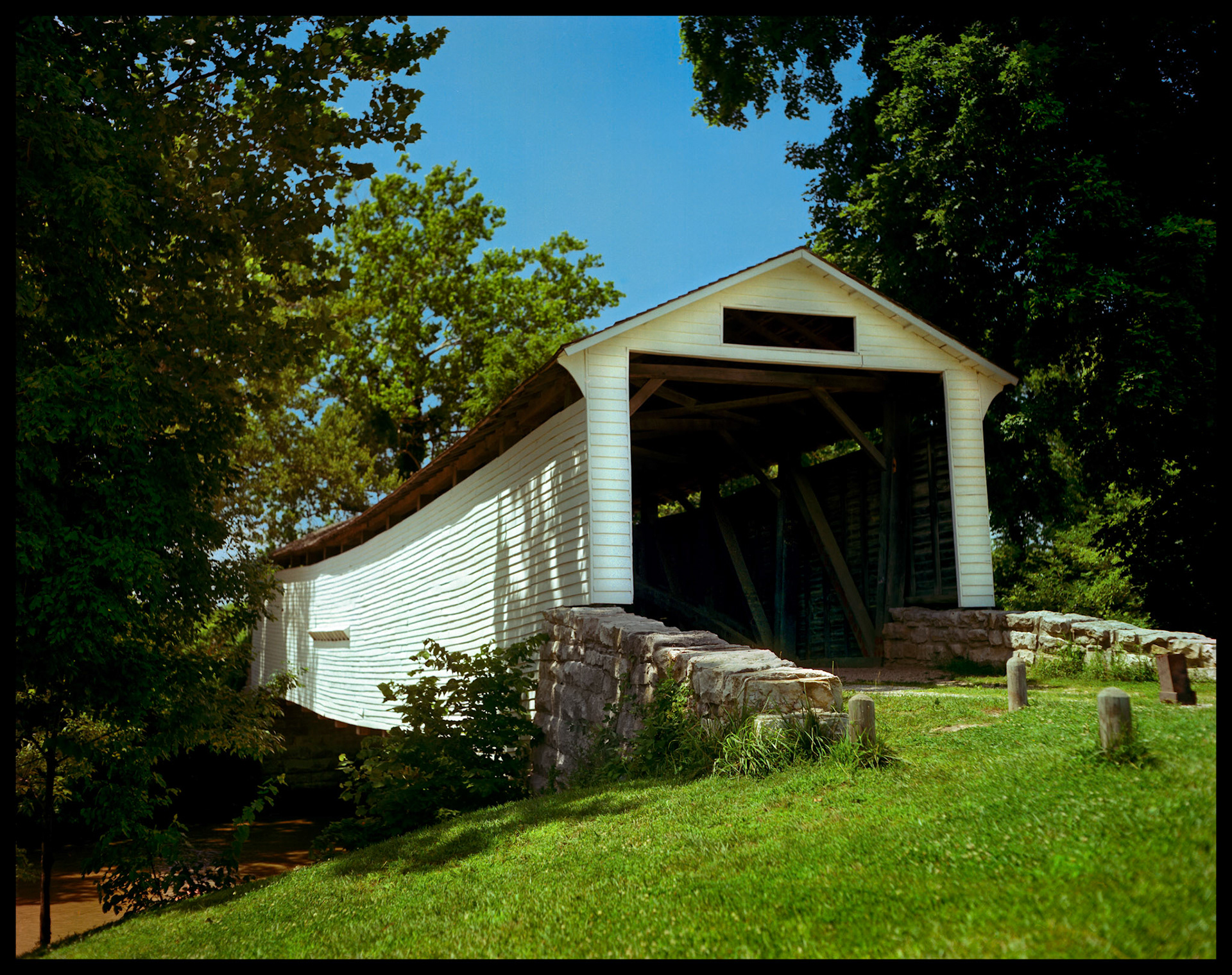 A 1982 vintage image of the Union Covered Bridge at the Union Covered Bridge State Historical Site near Paris, Missouri. The Union Covered Bridge, built in 1871, spans the Elk Fork of the Salt River in Monroe County Missouri and is the only one of the four remaining covered bridges in Missouri that represents the Burr-arch truss design. It served travelers in Monroe County for 99 years.