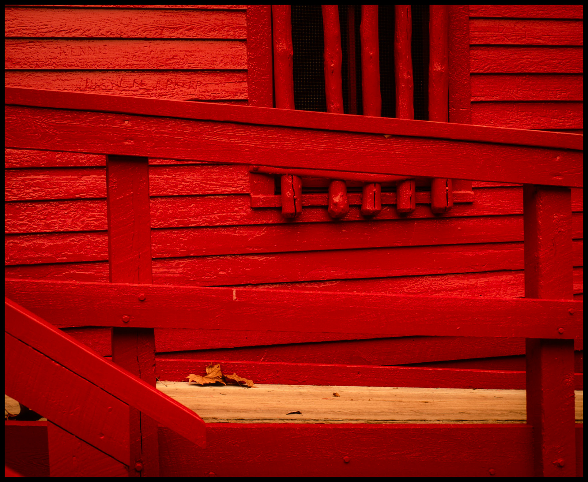 A geometric study of the bright red hand rails and building with some fallen Autumn leaves on the walkway at Alley Spring Mill near Eminence, MO in the Ozark mountains. 1988