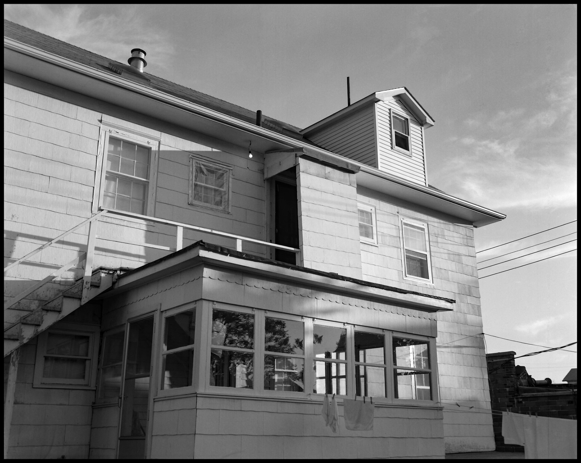 A late afternoon view of the back of an older home converted to an apartment building making an interesting composition. Kirksville, Missouri USA 1985.
