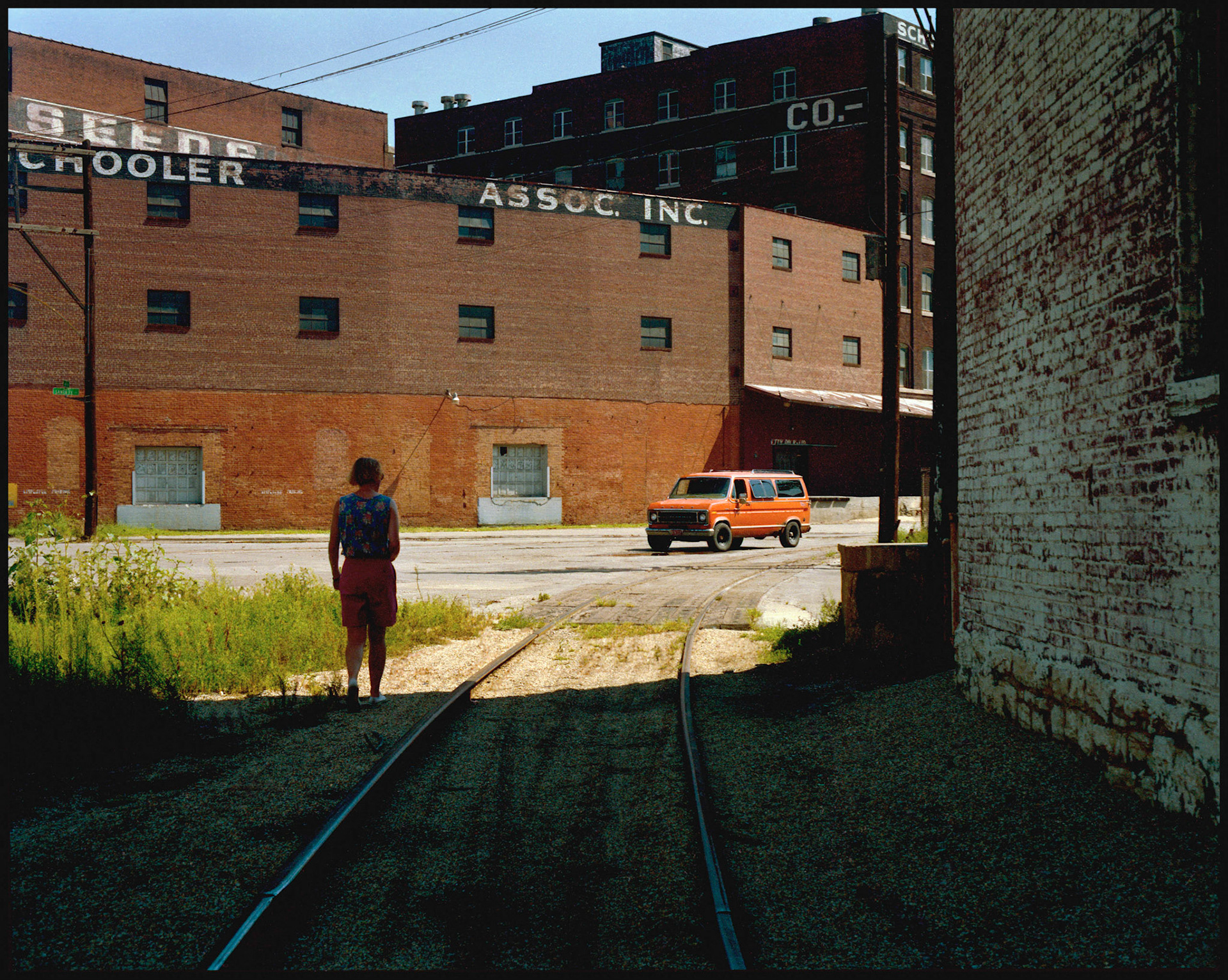 A woman emerging from the shadows in the industrial area of the Kansas City, Missouri West Bottoms. 1990