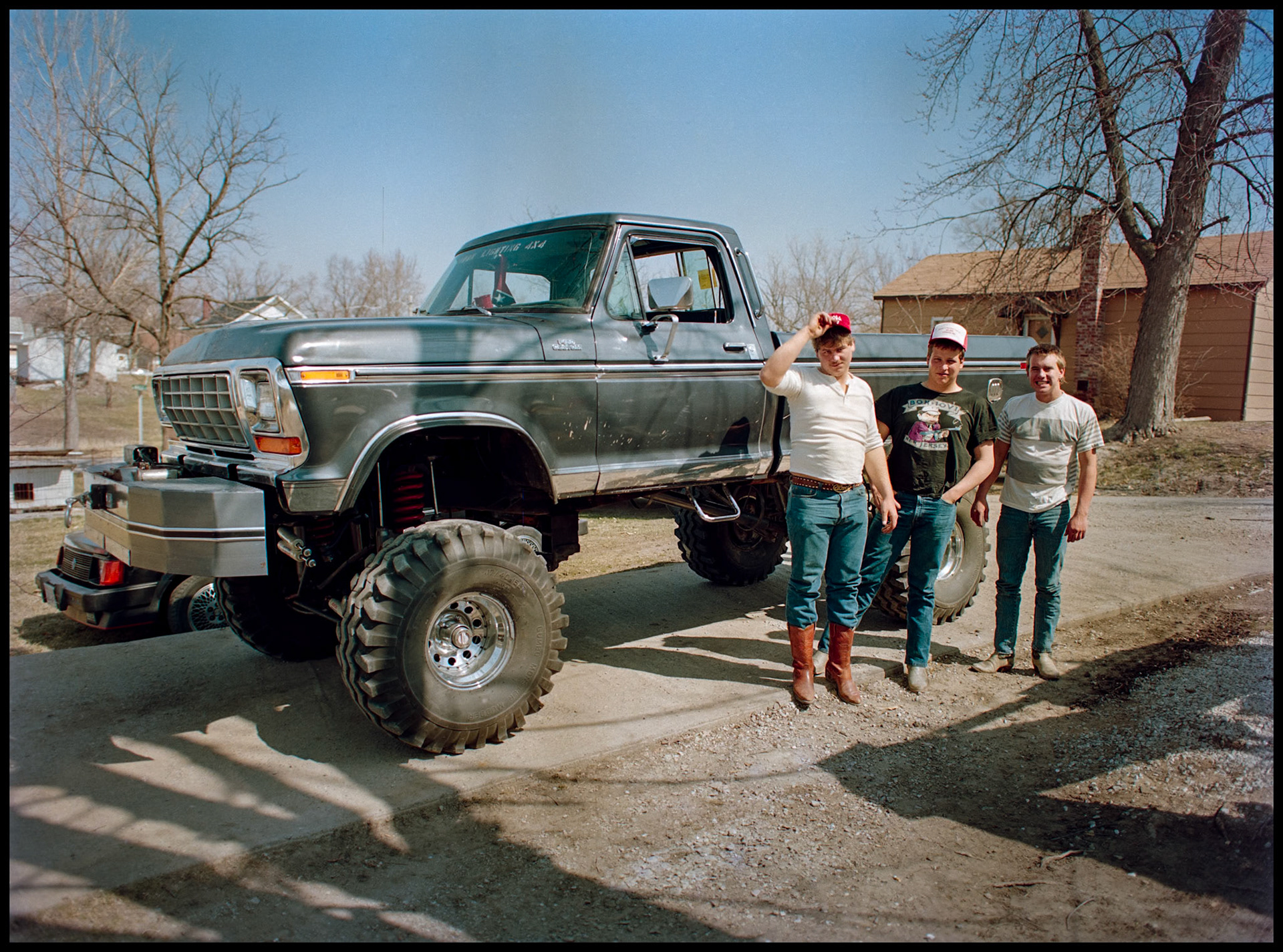 Three young men standing next to their lifted Ford F-150 pickup. Kirksville, Missouri 1989