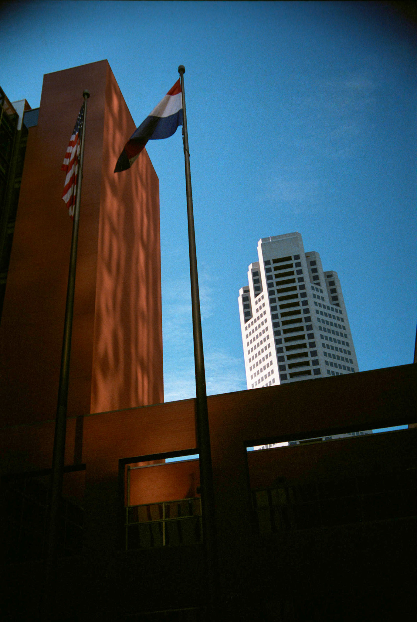 U.S. and Missouri flag in front of a portion of the St. Louis Place Building with the AT&amp;T Canter in looming in the backgrond in downtown St. Louis, Missouri, 1988. Part of a series shot one warm afternoon in November, 1988 called An Afternoon in St. Louis (a subset of my Industrial Geometry series).