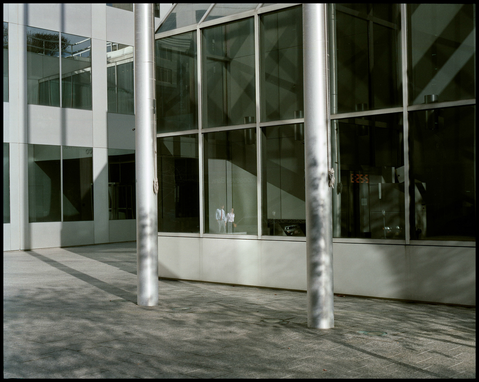 A young pedestrian couple reflected in the window of a downtown St. Louis metal and glass bank building. Part of a series shot one afternoon in November, 1988 called An Afternoon in St. Louis (a subset of my Industrial Geometry series).