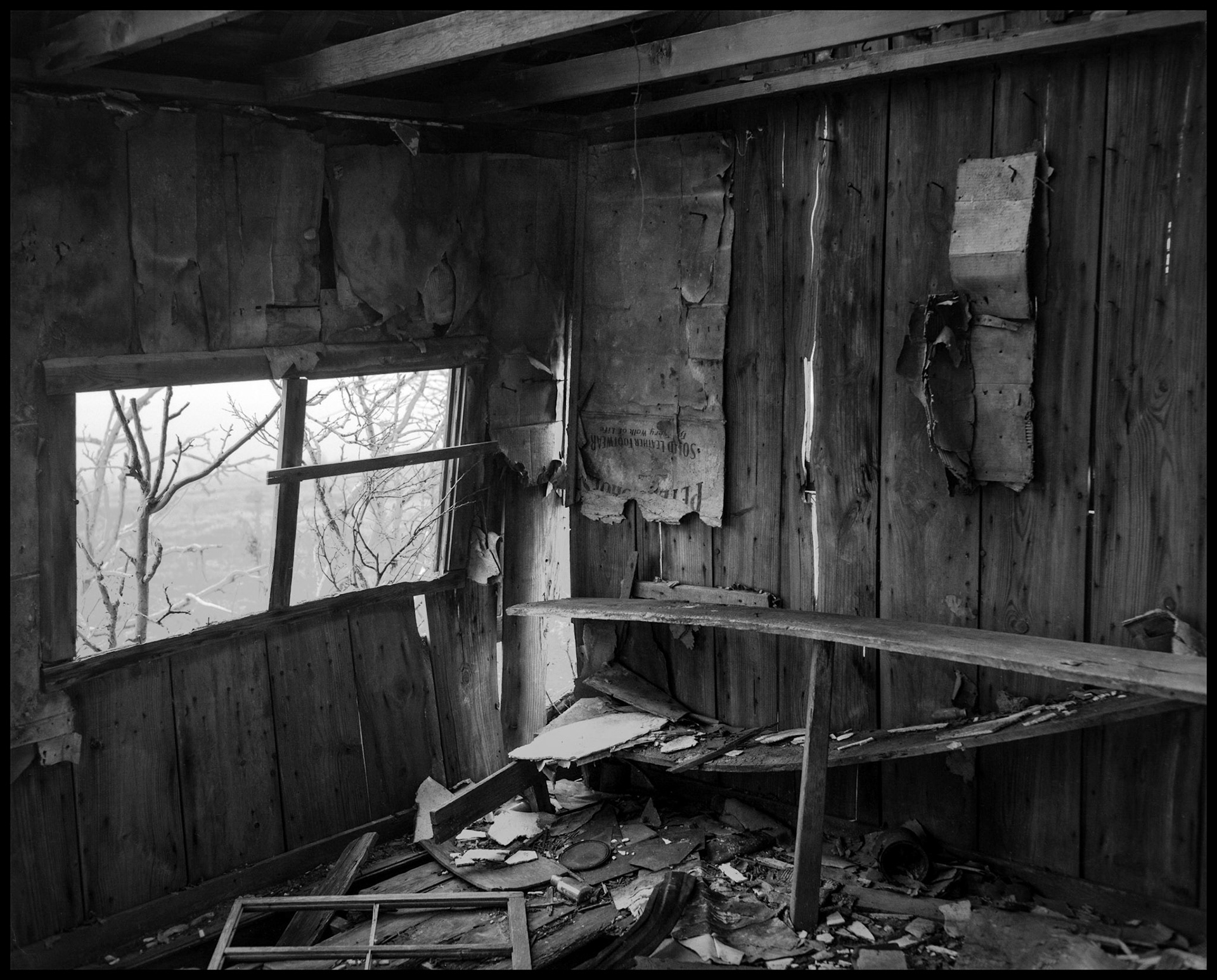 A rustic black and white still life of the interior of an abandoned farm building with remnants of many years of use.  Near New Boston, Missouri USA, 1980