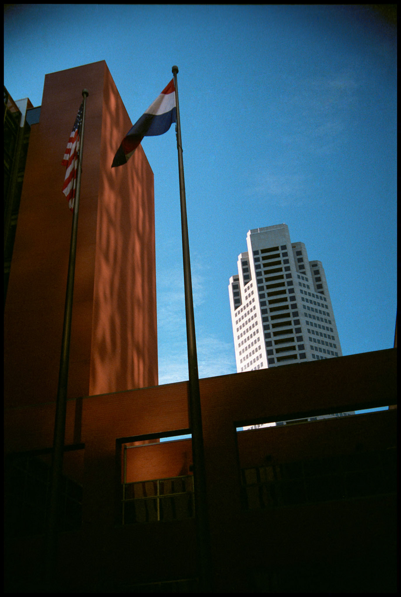 U.S. and Missouri flag in front of a portion of the St. Louis Place Building with the AT&amp;T Canter in looming in the backgrond in downtown St. Louis, Missouri, 1988. Part of a series shot one warm afternoon in November, 1988 called An Afternoon in St. Louis (a subset of my Industrial Geometry series).