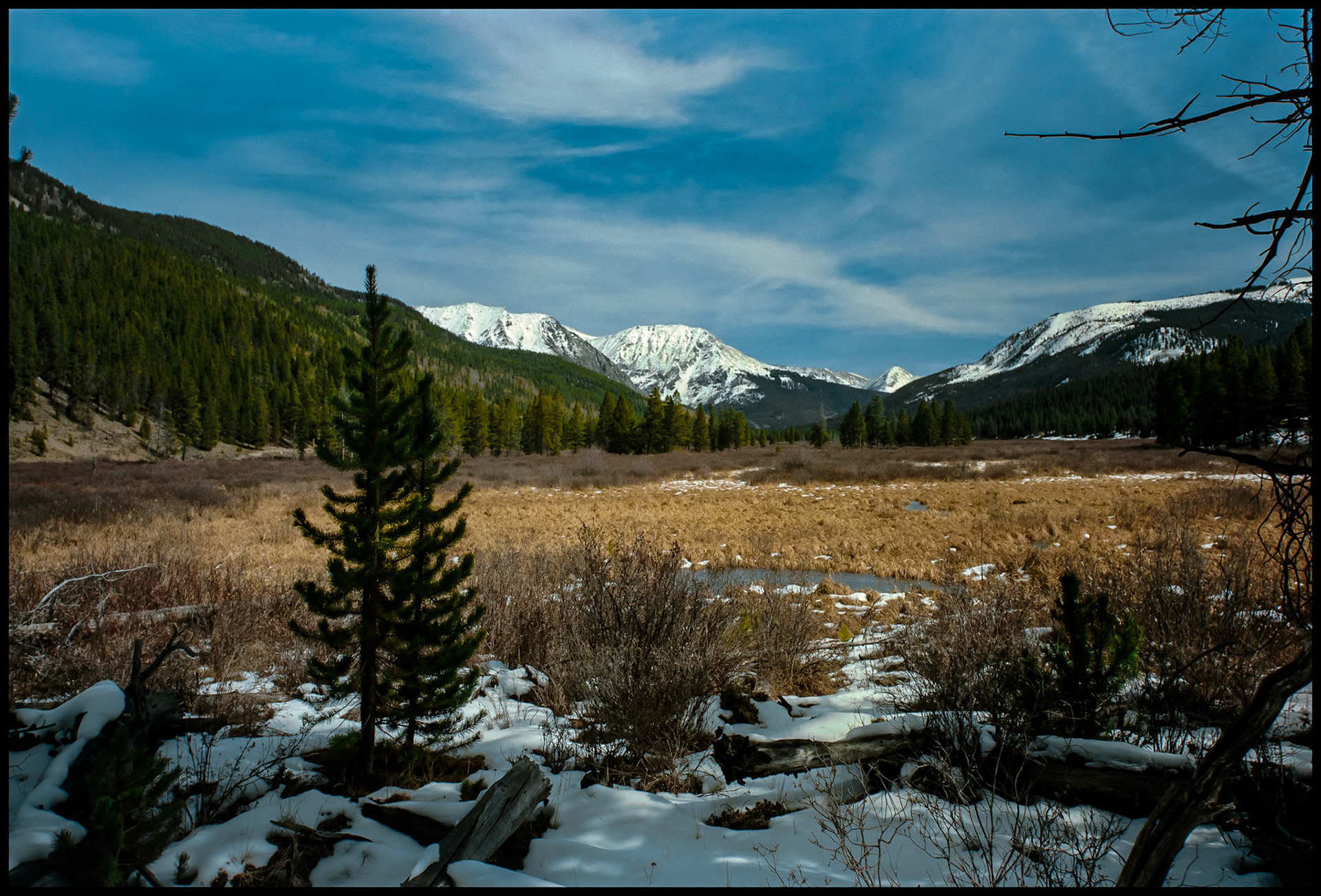 A view of the snowcapped Collegiate Peaks area in the Sawatch mountain range from the shore of one of the Texas Lakes in Taylor Park near Tincup, Colorado USA