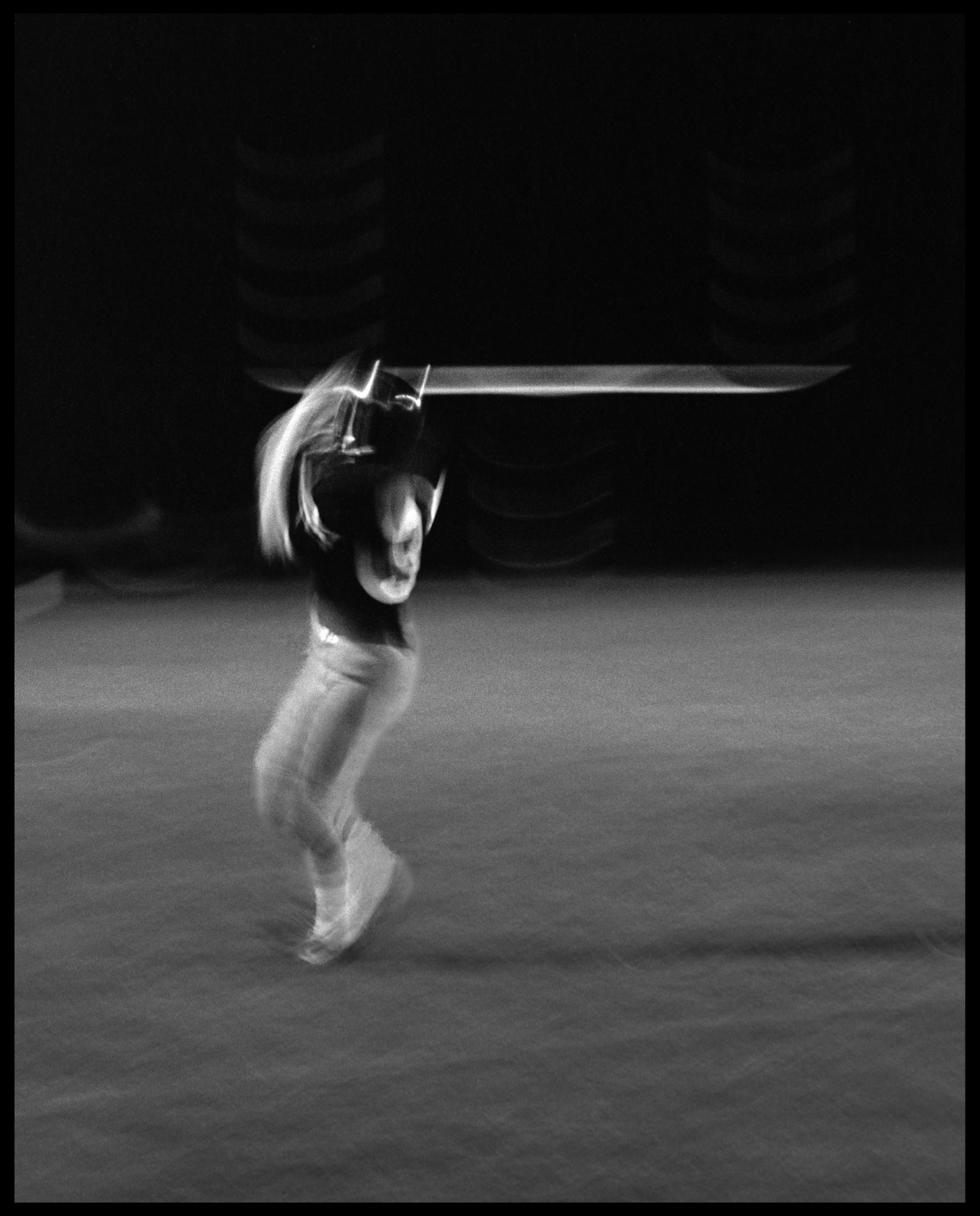 A motion study shot using the rear curtain flash sync technique of a football player catching a pass over his shoulder. Kirksville, Missouri, 1978.