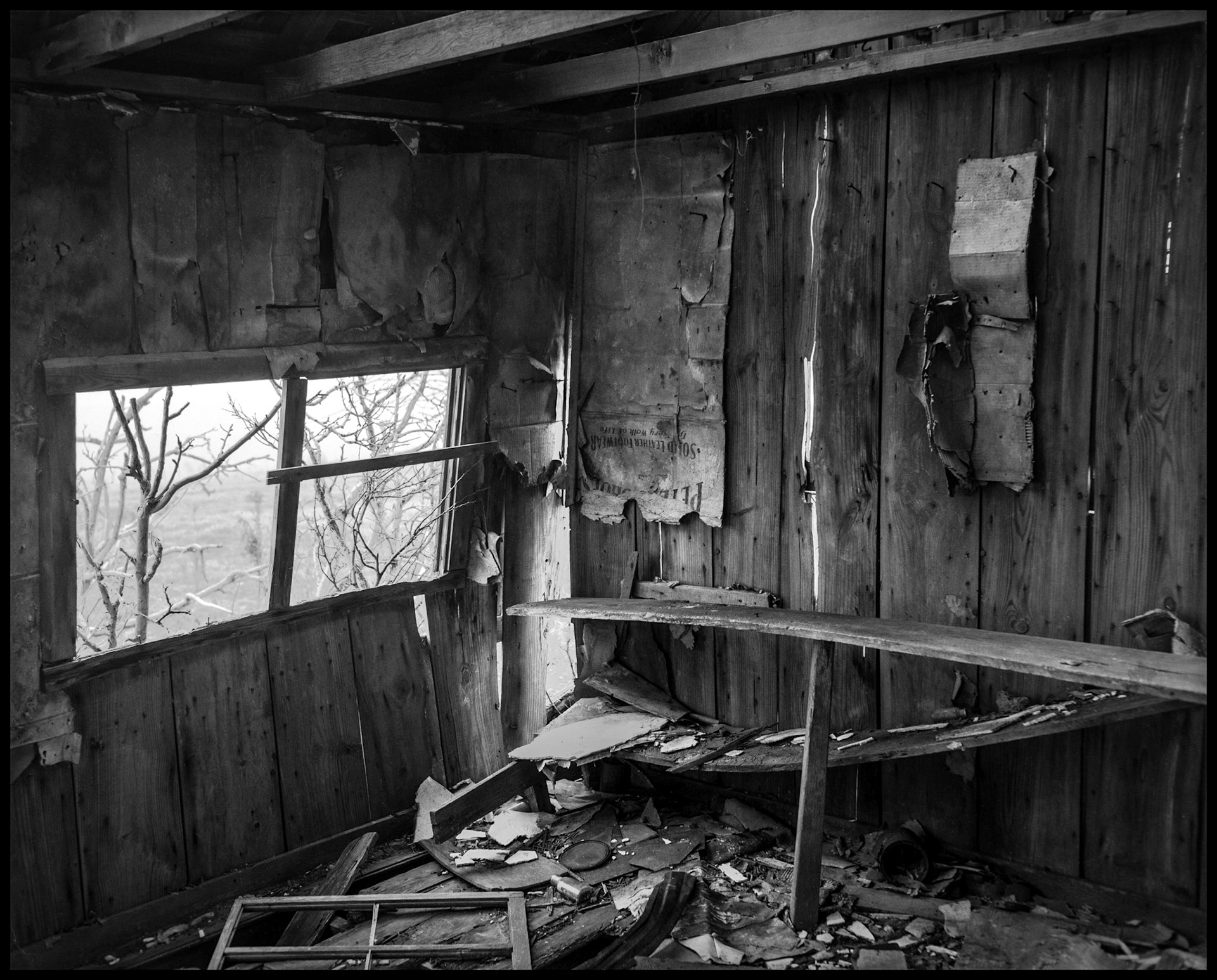 A rustic black and white still life of the interior of an abandoned farm building with remnants of many years of use.  Near New Boston, Missouri USA, 1980
