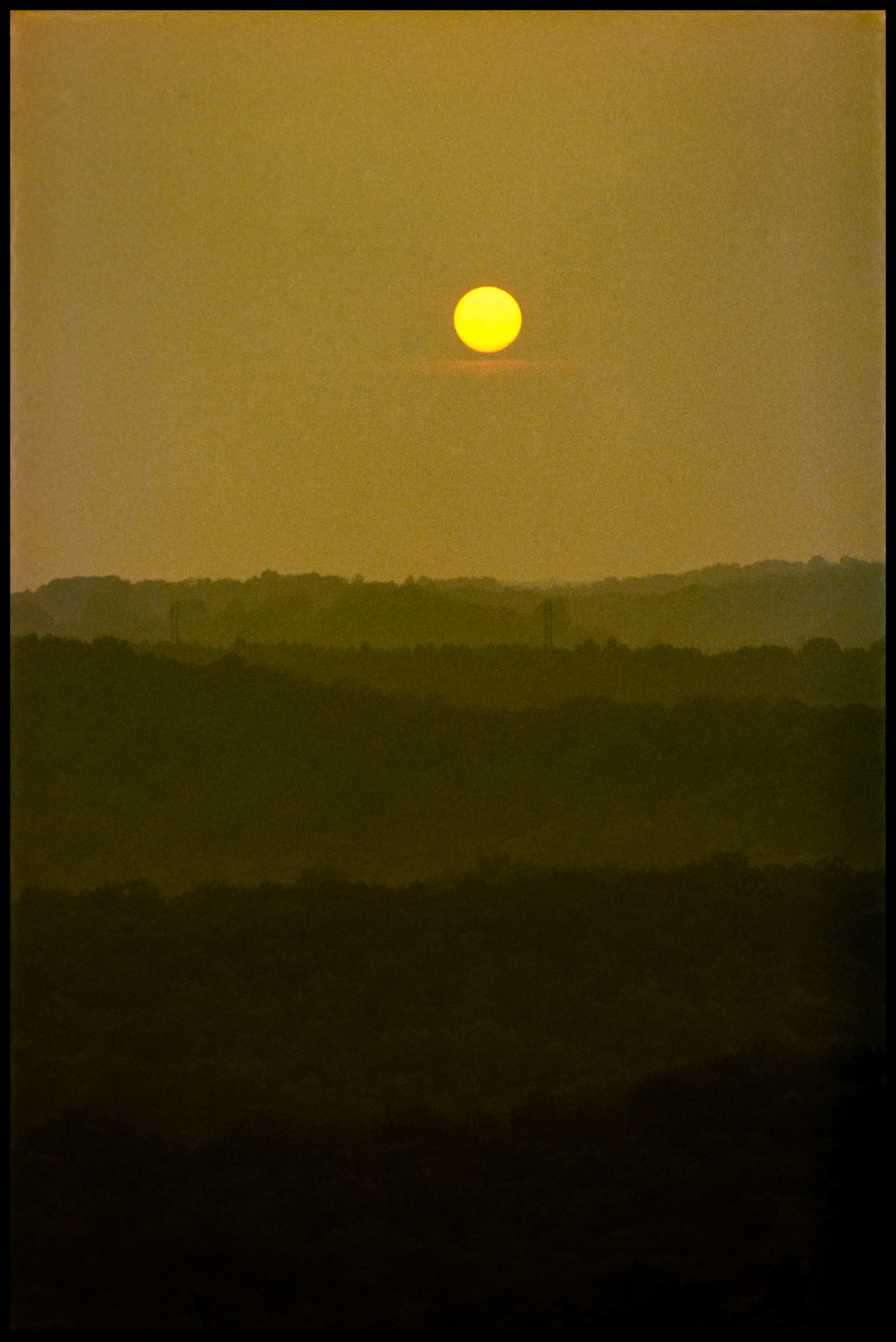 A golden sunset over multiple misty layers of the Ozark mountains near Shepard of the Hills, Branson, Missouri 1982