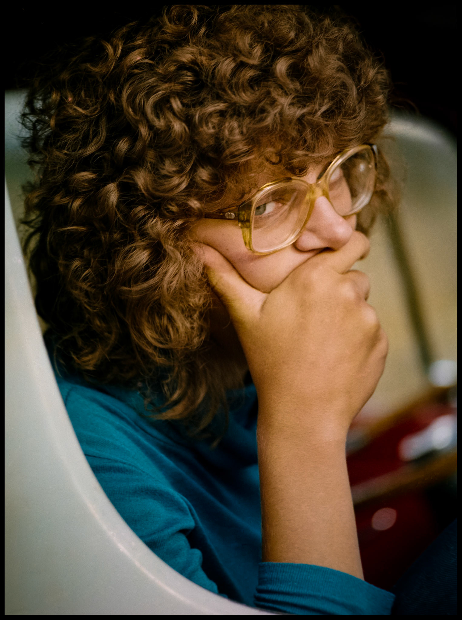 A 1980's vintage portrait of a young woman sitting in a van giving the photographer the evil eye. Near Tin Cup, Colorado 1981
