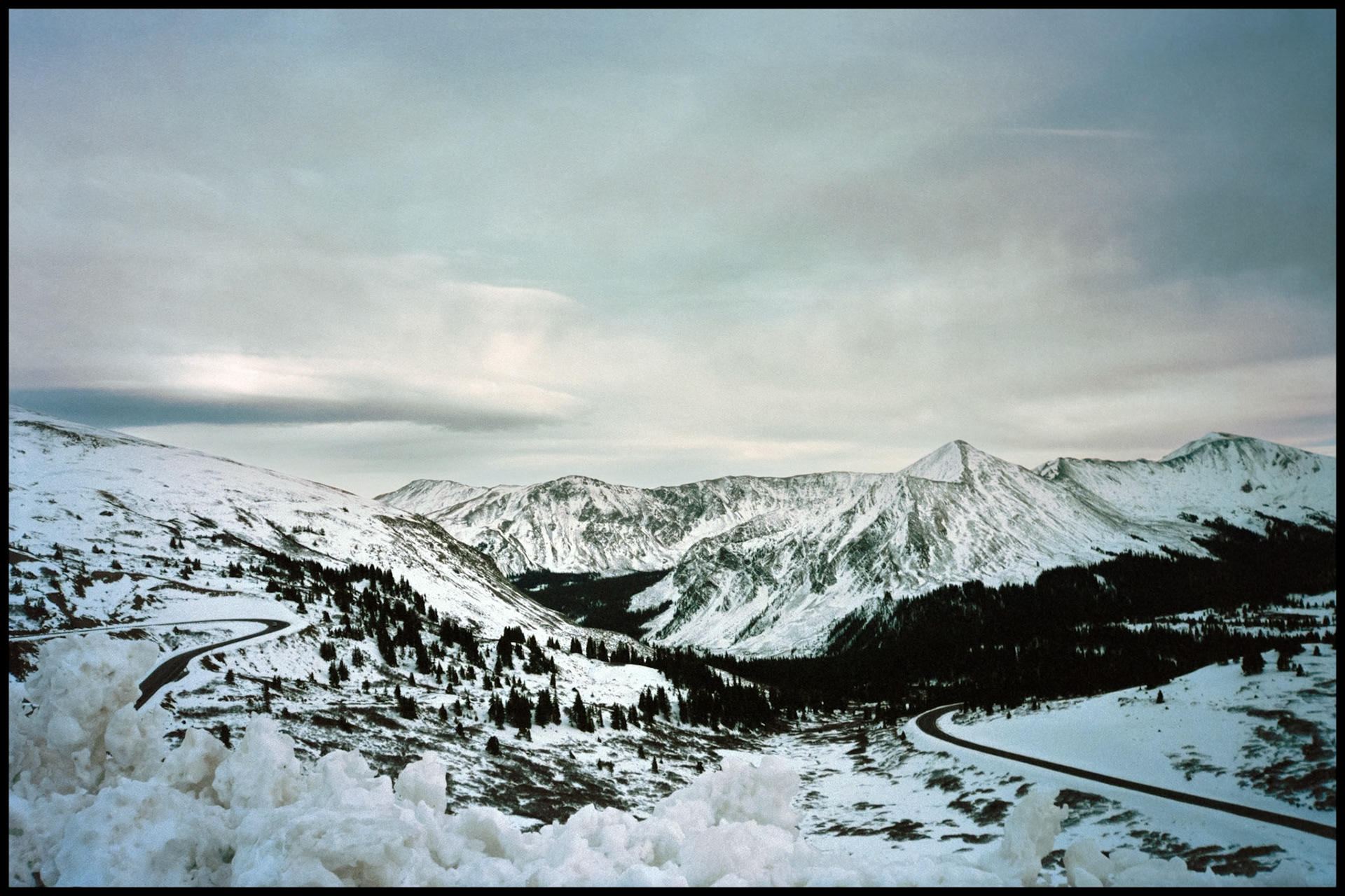 A Westward view of snow covered mountains in the Sawatch Range from the top of Cottonwood Pass on a gloomy overcast day in October. Between Buena Vista and Taylor Park in Southwest Colorado USA 1993