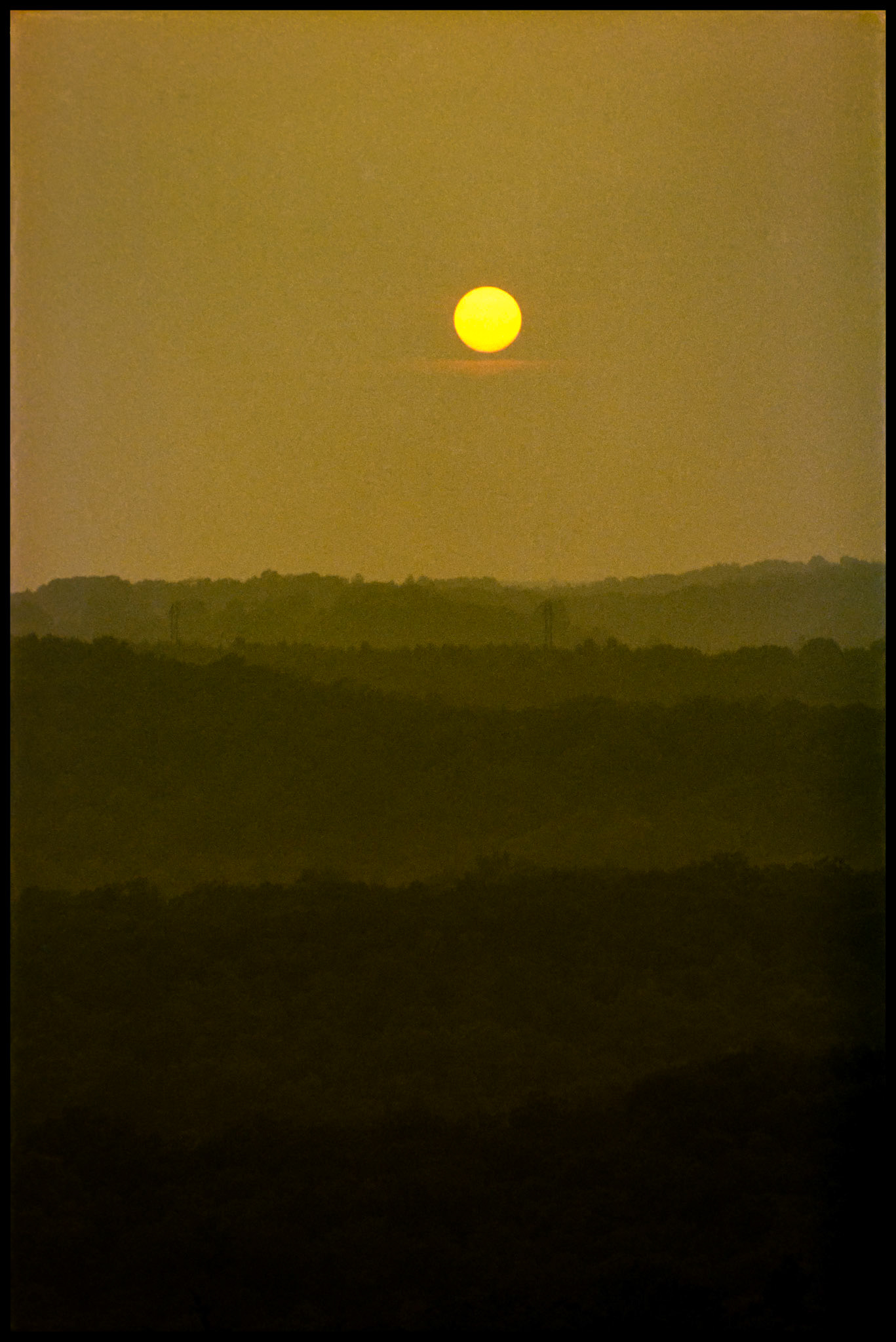 A golden sunset over multiple misty layers of the Ozark mountains near Shepard of the Hills, Branson, Missouri 1982