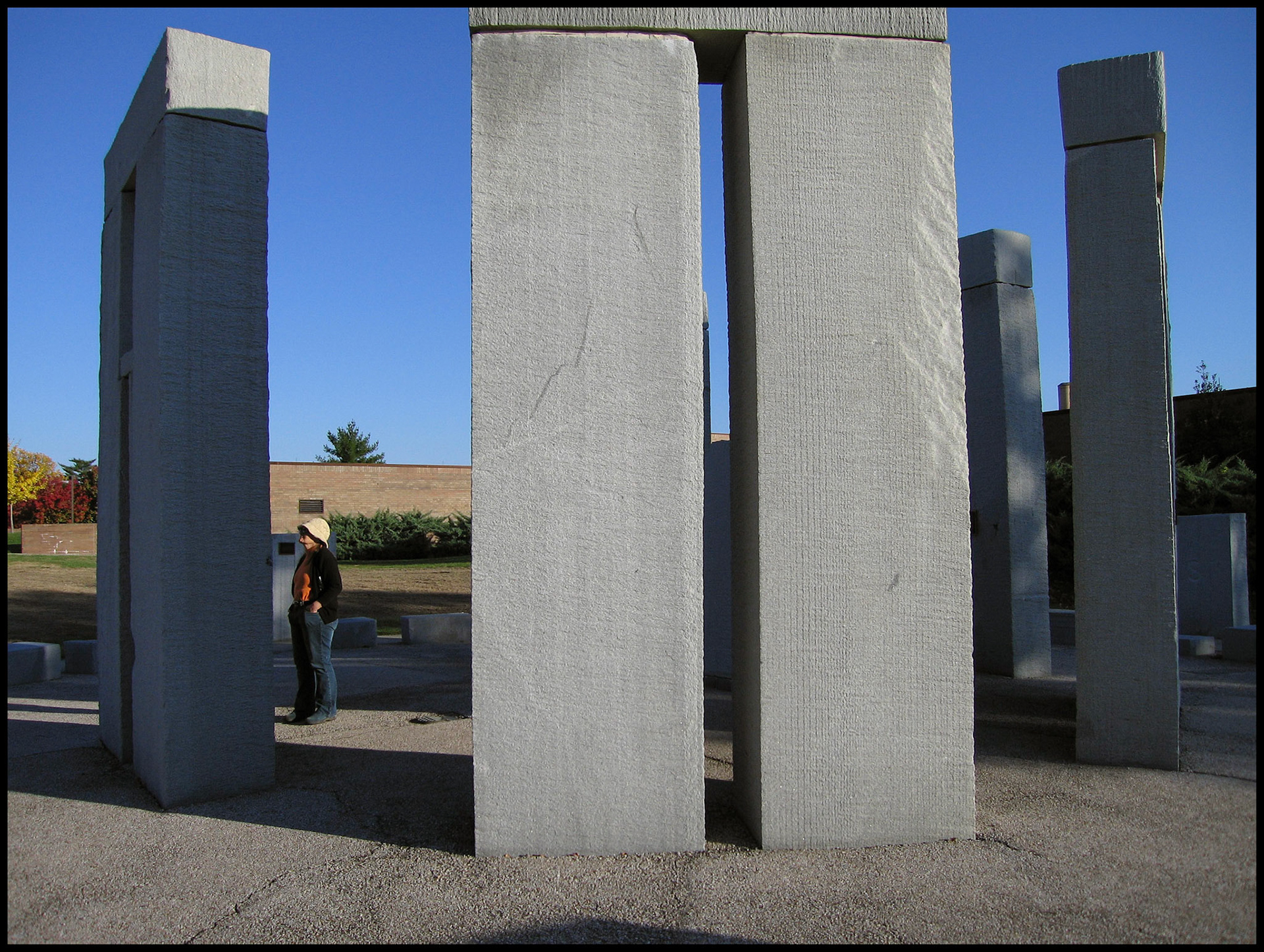 A woman inspecting a Stonehenge replica at  Missouri University of Science and Technology. This half-scale replica of Stonehenge was created to demonstrate water-jet technology.  Rolla, Missouri USA 2006