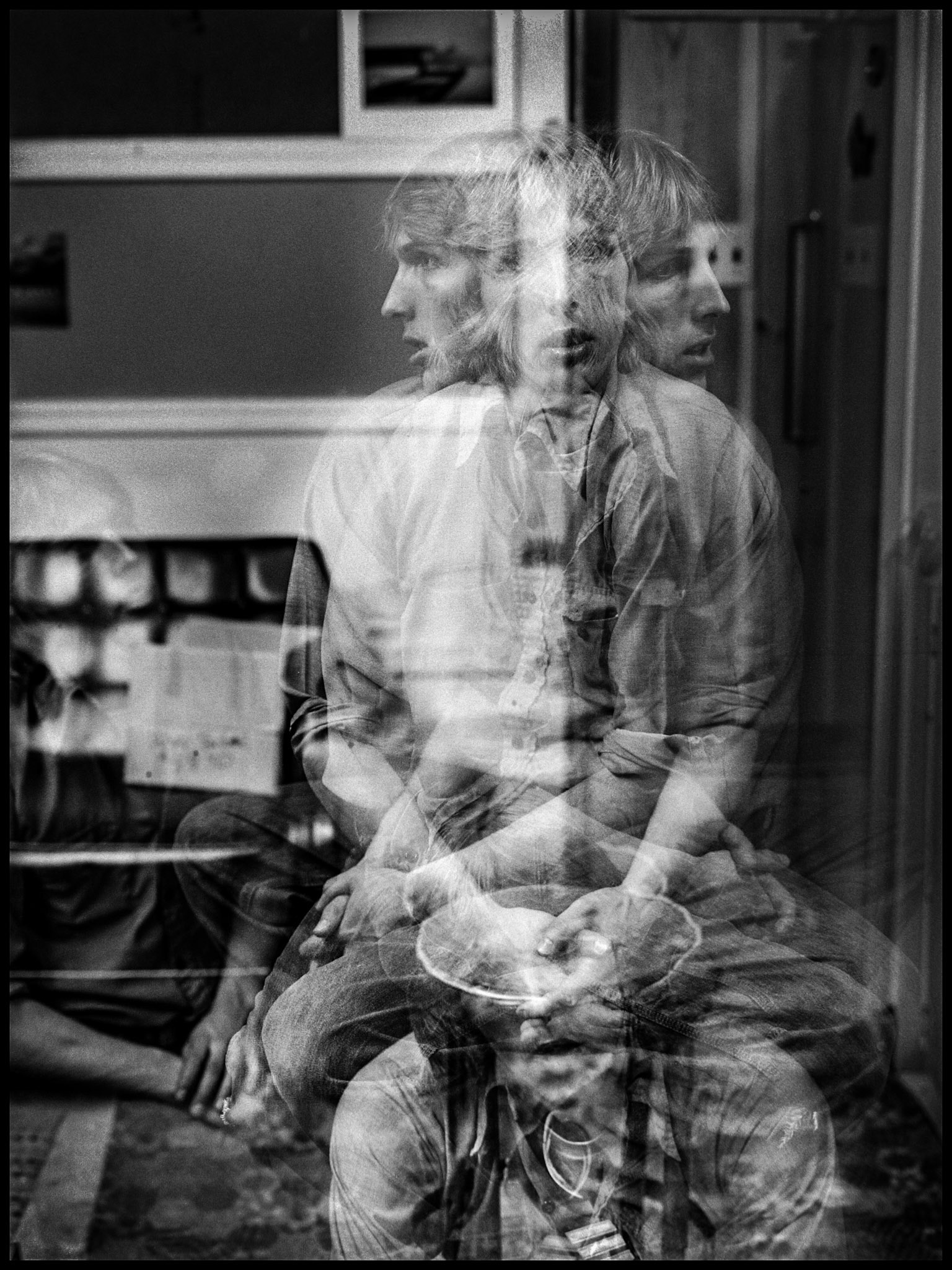 A 1970's vintage in-camera film mutiple exposure of a young man sitting on a stool, rotating between exposures and assuming a couple of other positions to illustrate the feeling of being pulled in multiple directions. Kirksville, Missouri 1979