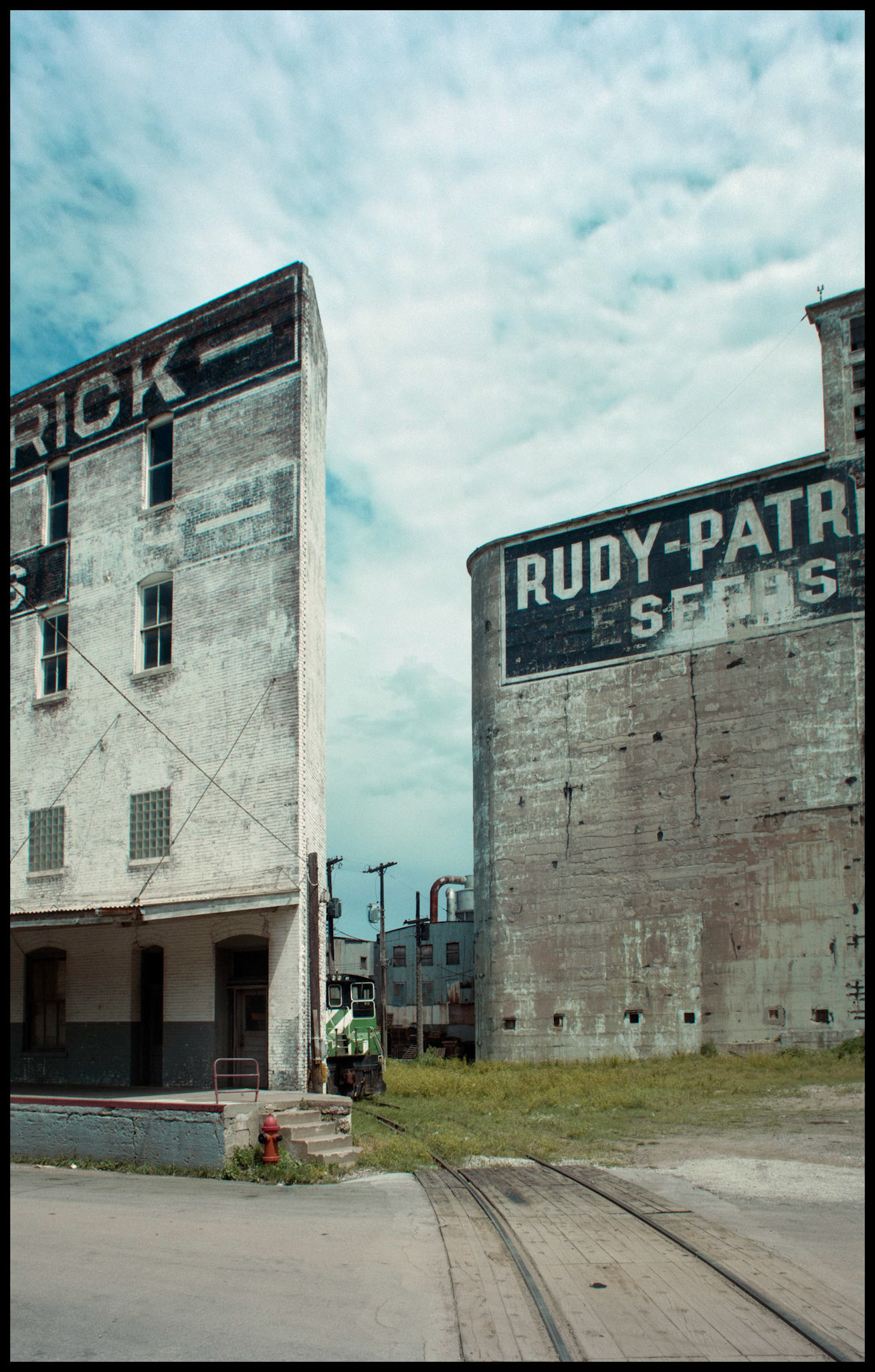 Illinois Street House back porch and steps, Kansas City West Bottoms Ruby Seed, fire hydrant, wall and sky