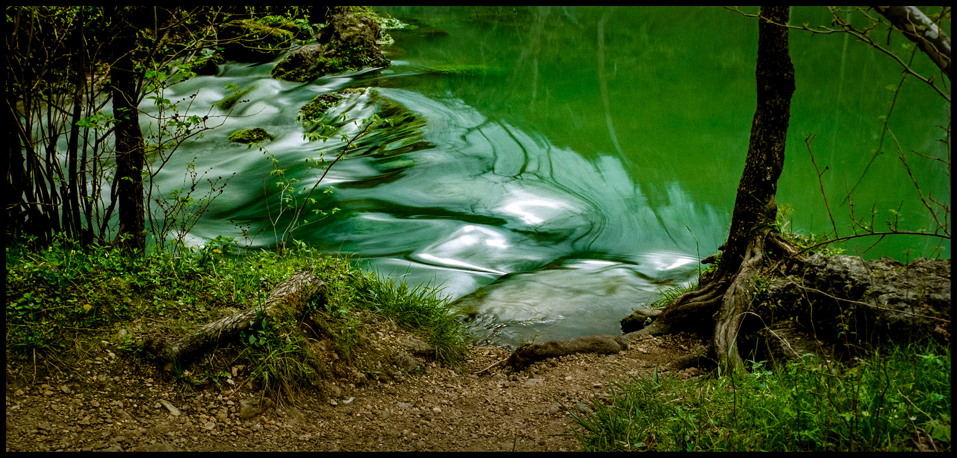 Swirling water and reflections seemingly distorting our perception of the world. Alley Spring Branch Creek at Alley Spring Mill near Eminence, Missouri. 1993