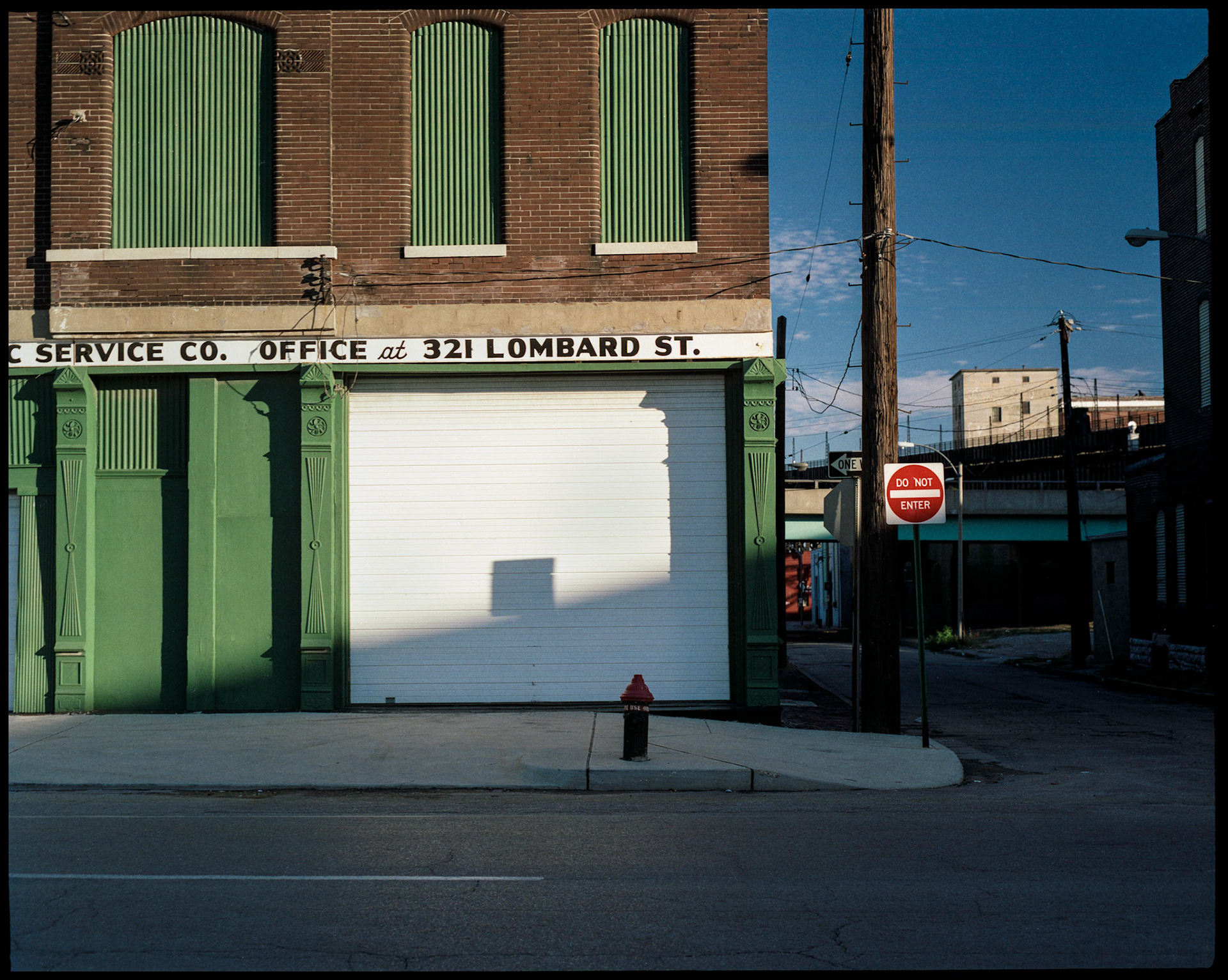The shadow of a road sign on the garage door of a commercial building in downtown St. Louis, Missouri. Part of a series shot one afternoon in November, 1988 called An Afternoon in St. Louis (a subset of my Industrial Geometry series).