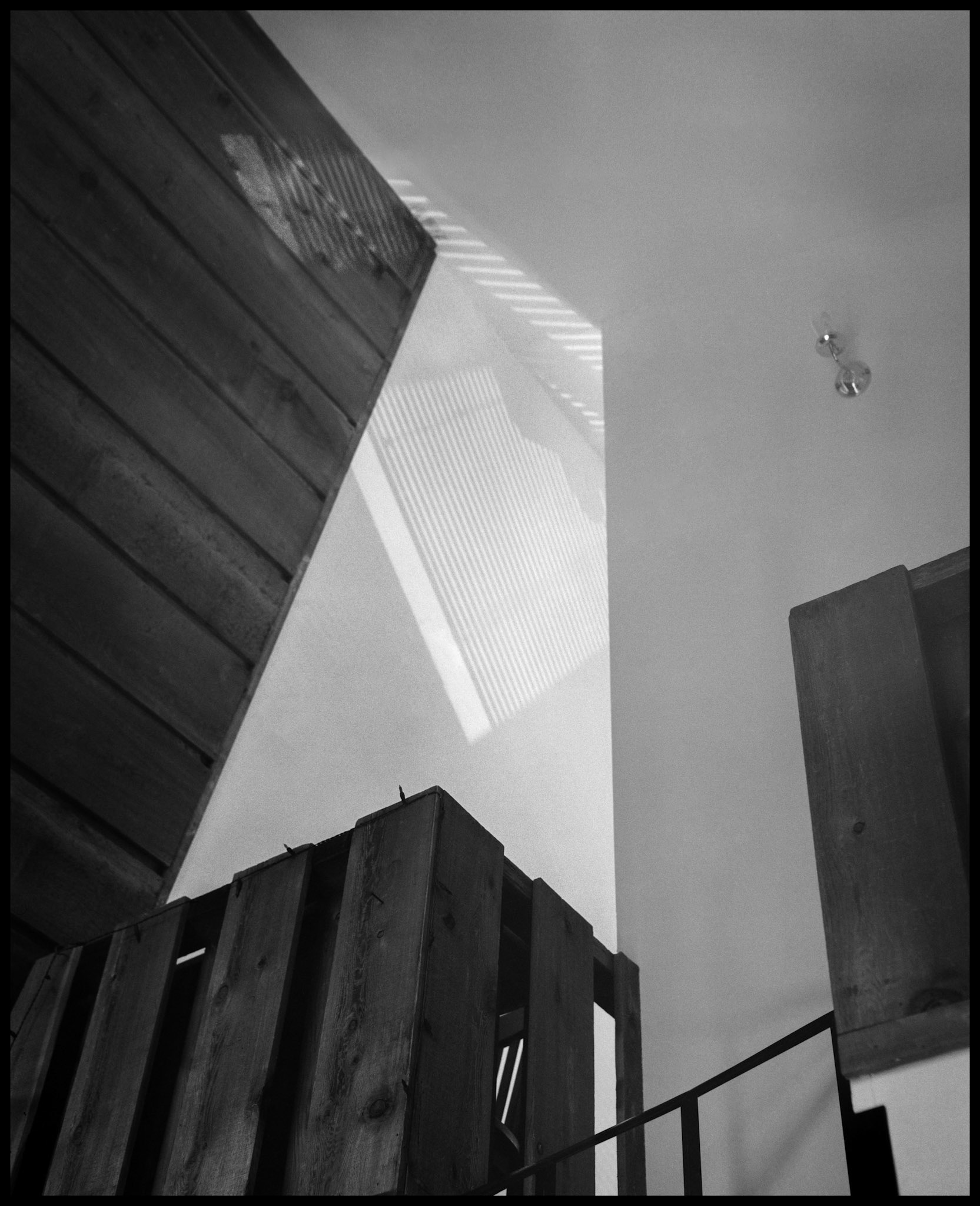 A black and white minimal abstract composition of afternoon highlights and shadows on the interior wall of an A-Frame house. Near Rocheport, Missouri 1993