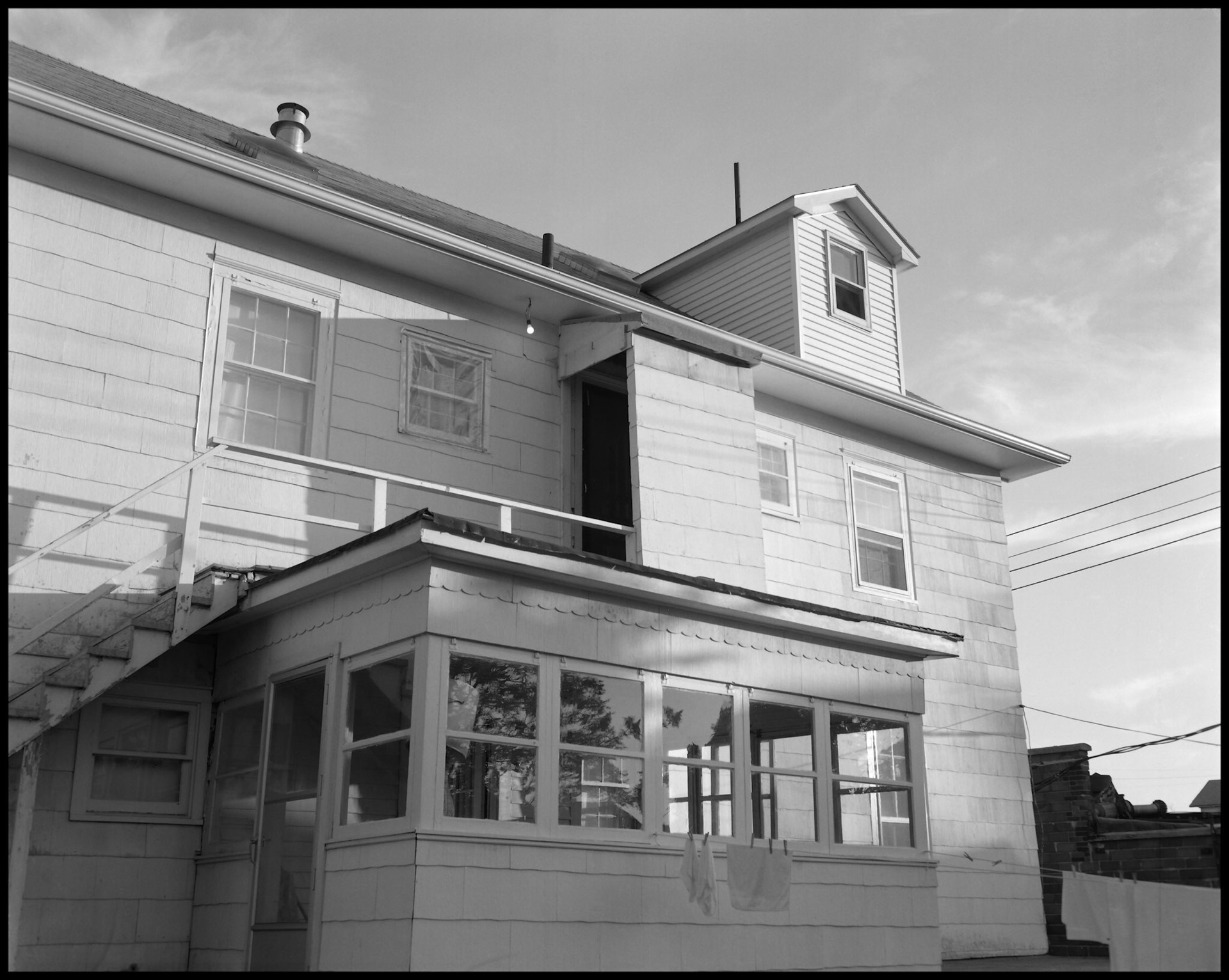 A late afternoon view of the back of an older home converted to an apartment building making an interesting composition. Kirksville, Missouri USA 1985.