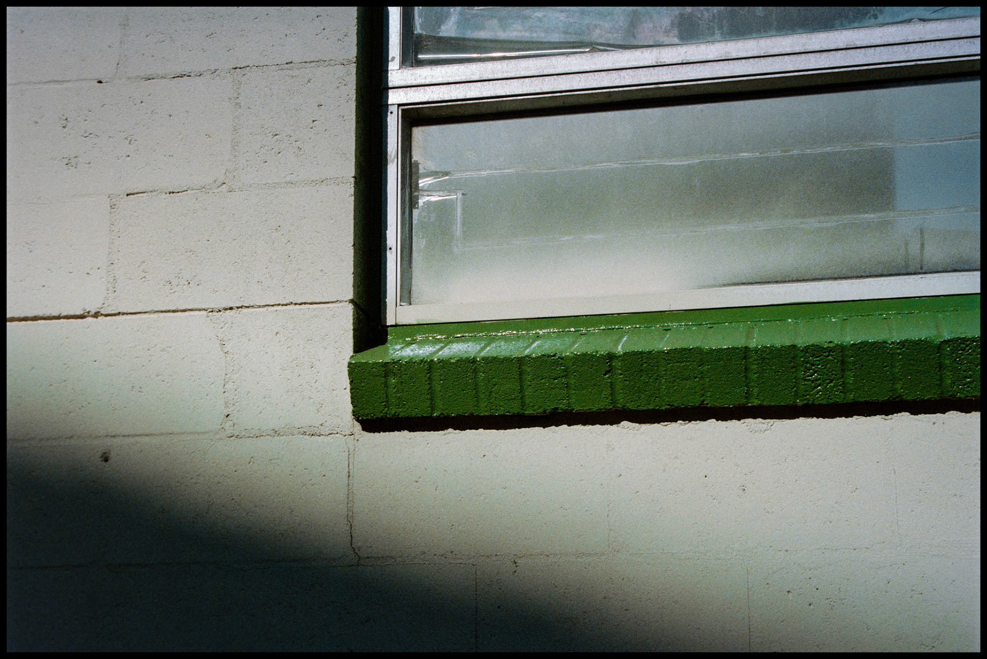 A minimal abstract detail of a green window sill on a cement block building. Kansas City, Missouri 1984