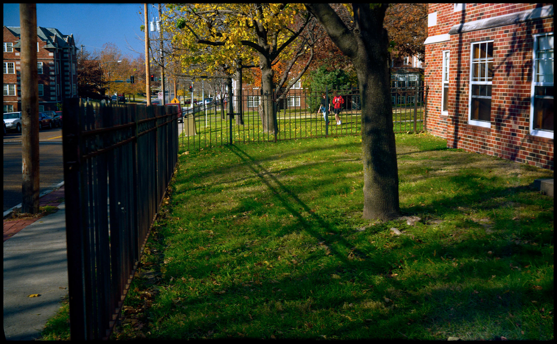The shadow of a wrought iron fence with students in the background outside the Curved Entrance Gallery, Stephens College, Columbia, Missouri 1989