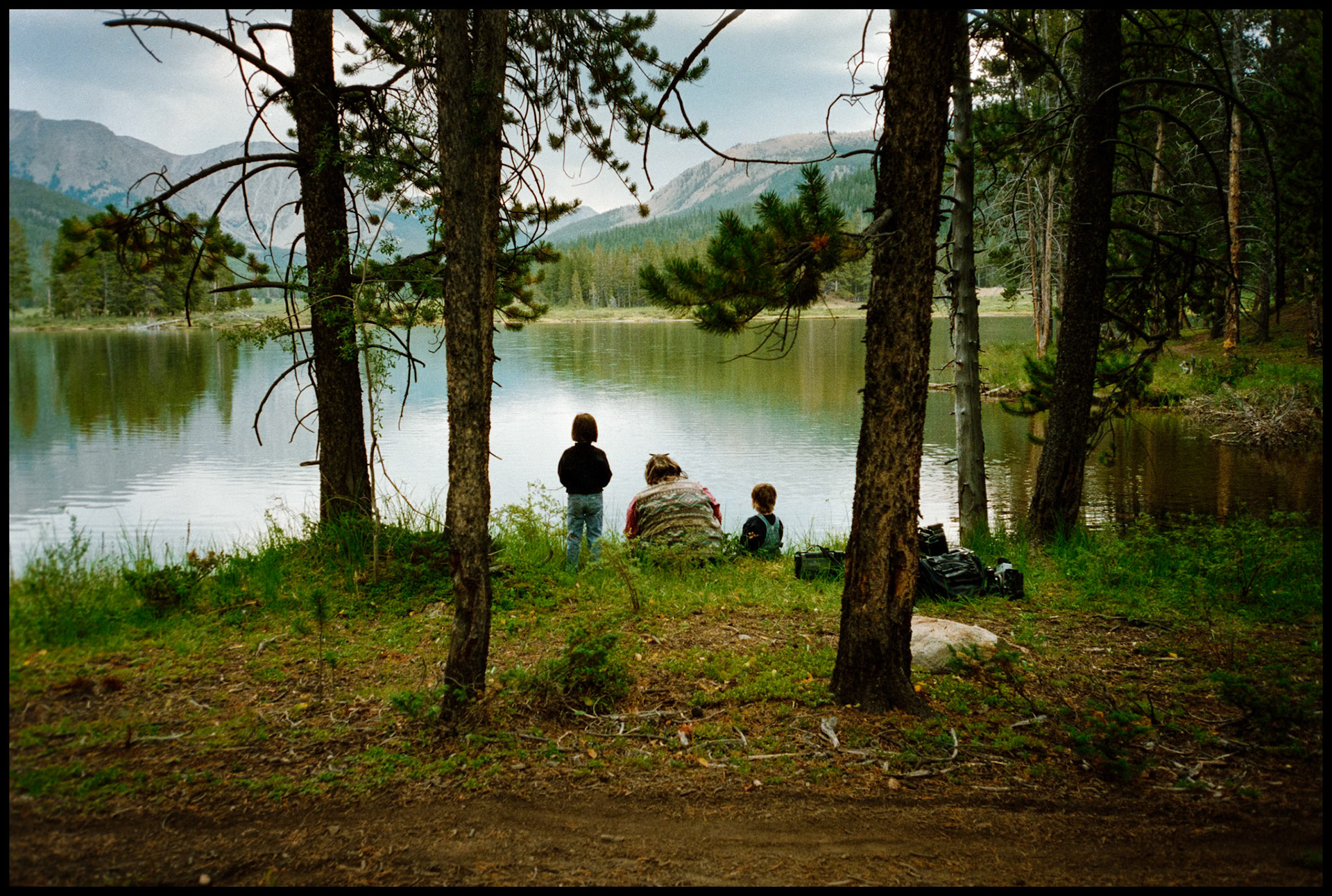 A mother and her two young daughters soaking in the view from the shore of one of the Texas Lakes in Taylor Park near Tin Cup, Colorado. 1996