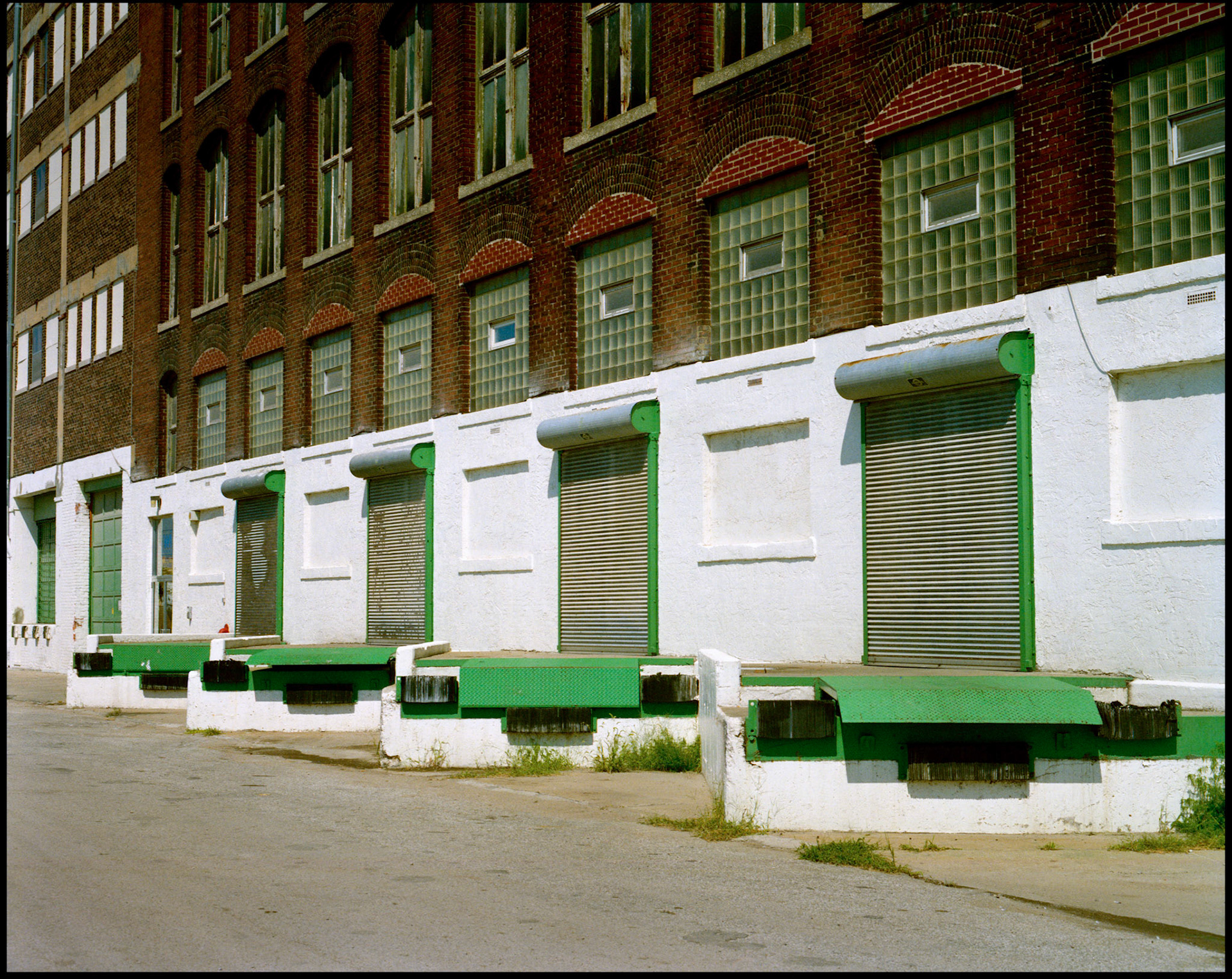 A row of empty loading docks with green trim making an interesting design in the industrial area of the West Bottoms of Kansas City Missouri. 1990