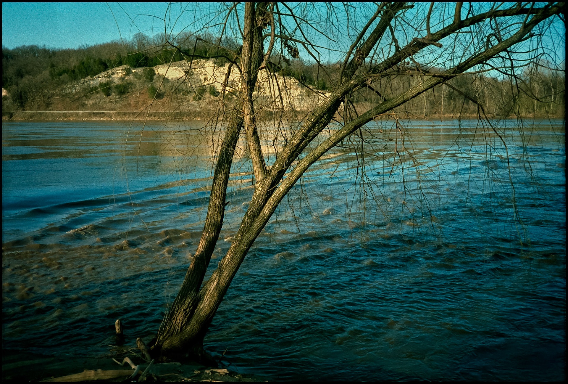 Rippling water of the Missouri River as it rises above it's banks just before the historic flood of 1993. Looking toward the bluff next to the Katy Trail, a former railroad line converted to a trail system.  Near Rocheport, Missouri USA