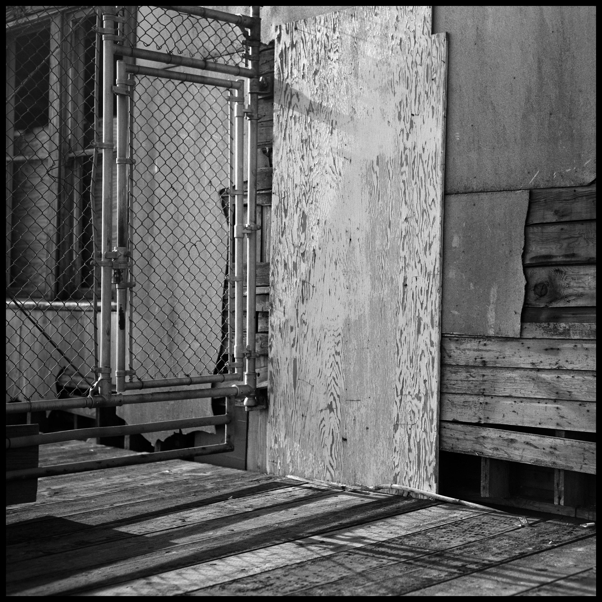 A vintage black and white image of a steel gate and patched wall on a pier on the Seattle waterfront. Seattle Washington USA 1987
