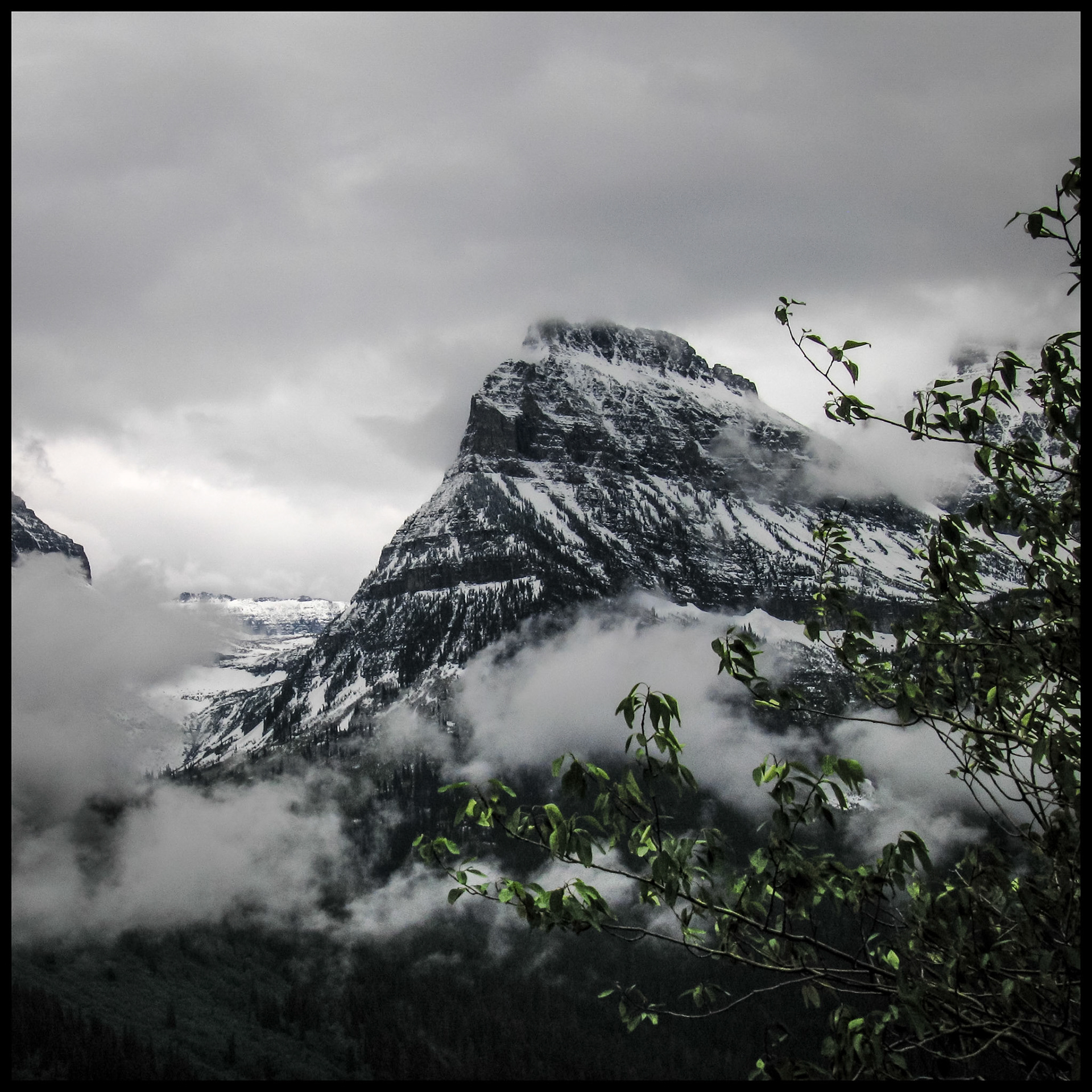 The snowy lower peak of Mt. Cannon in the clouds near Bird Woman Falls in Glacier National Park taken from Going-to-the-Sun Road on an overcast day. 2005