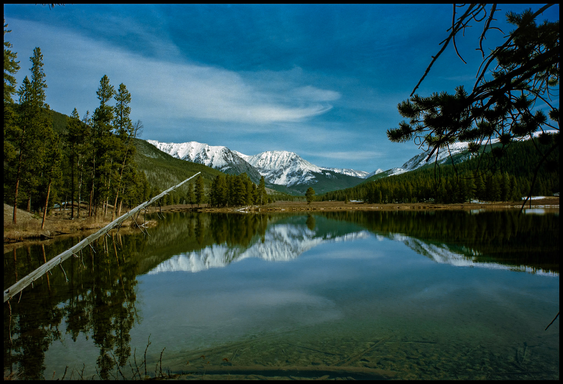 A view of the snowcapped Collegiate Peaks area in the Sawatch mountain range from the shore of one of the Texas Lakes in Taylor Park near Tincup, Colorado USA