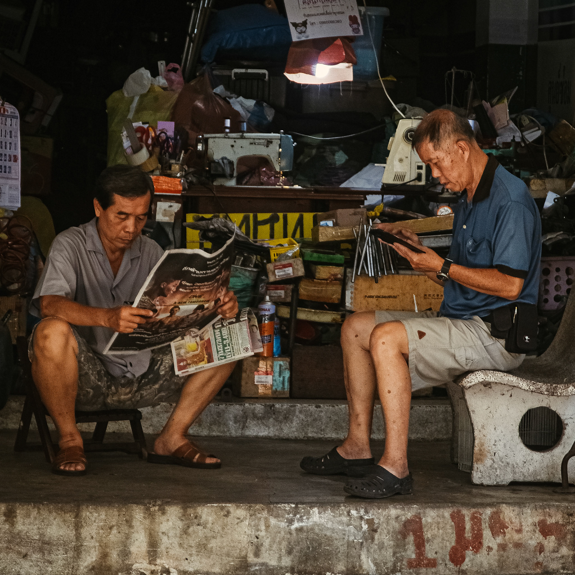 Two mens read in their workshop – Bangkok, Thailand