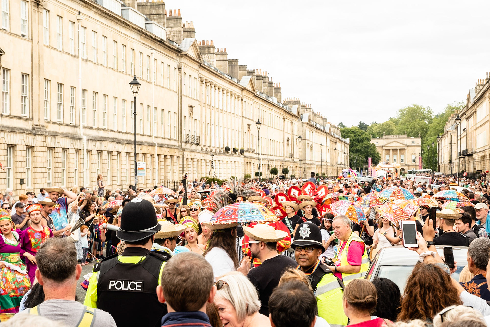 Pictured: Thousands of specators are drawn to the spectacle of the Carnival Parade, which snaked its way through the center of the historic city. Pultney Street Saturday 13th of July, Bath UK  Saturday 13th of July, Bath UK