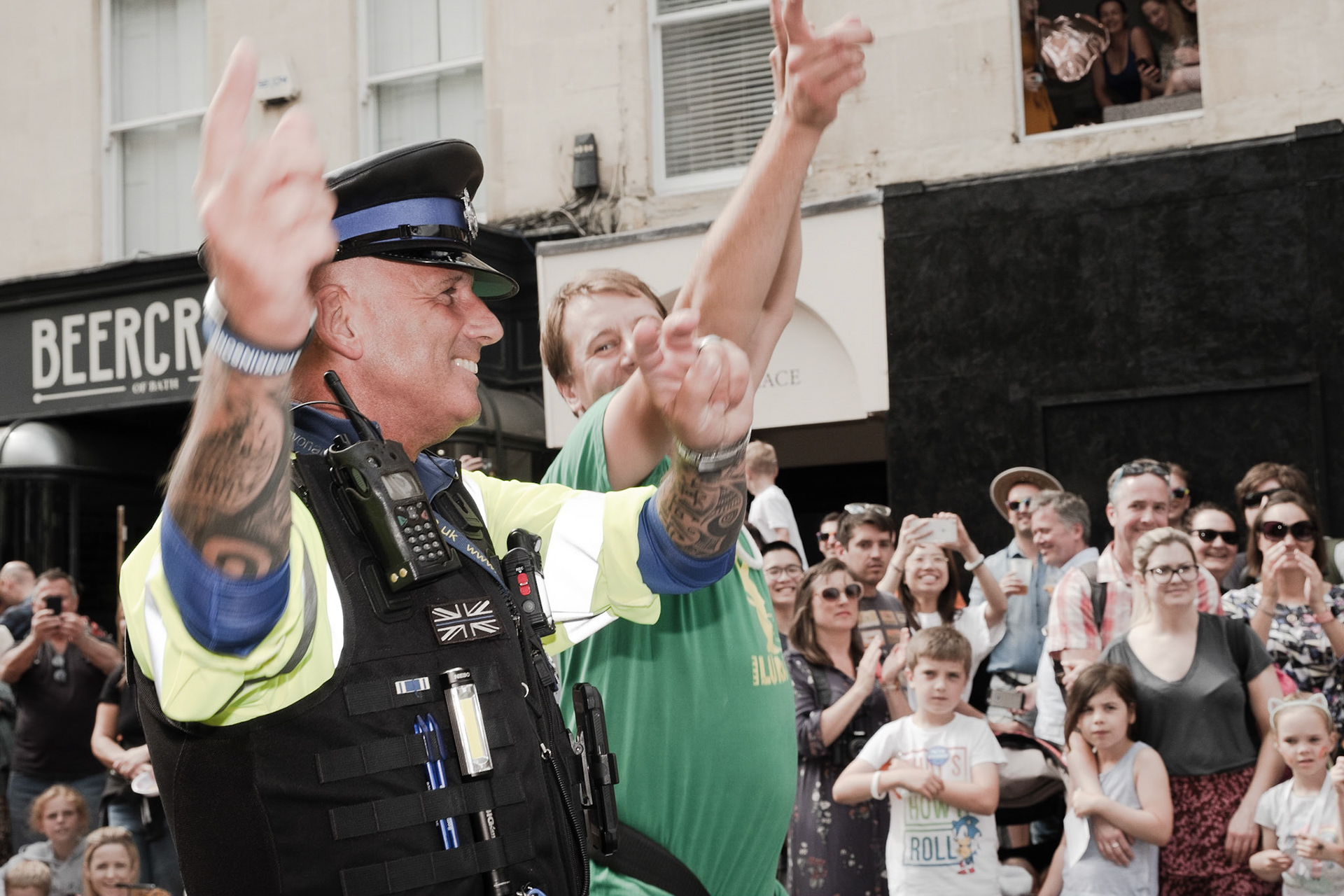 Pictured: Community Support Officer gets involved in the celebration by joining in with the dancing during the 2019 Bath Carnival Parade, Pultney Bridge, Bath, Saturday the 13th of July, UK