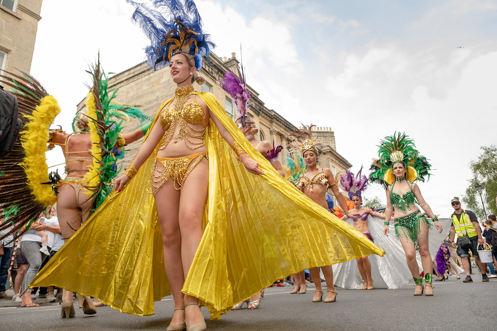 Pictured: Show-girls from Flaming Feathers troup entertain crowds with their vibrant colours and unique outfits as part of the Bath Carnival Parade. Saturday, July 13th Laura Place, Bath, Uk