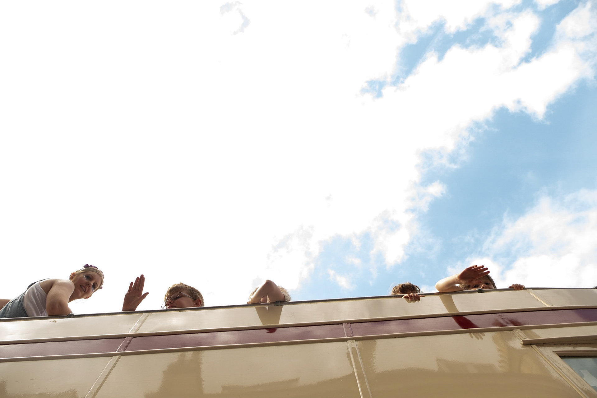 Pictured: A classic bus takes part of the 2019 Bath Carnival Parade whilst passengers enjoy a unique view of the celebrations. Saturday July 13th, Pultney Bridge, Bath, UK