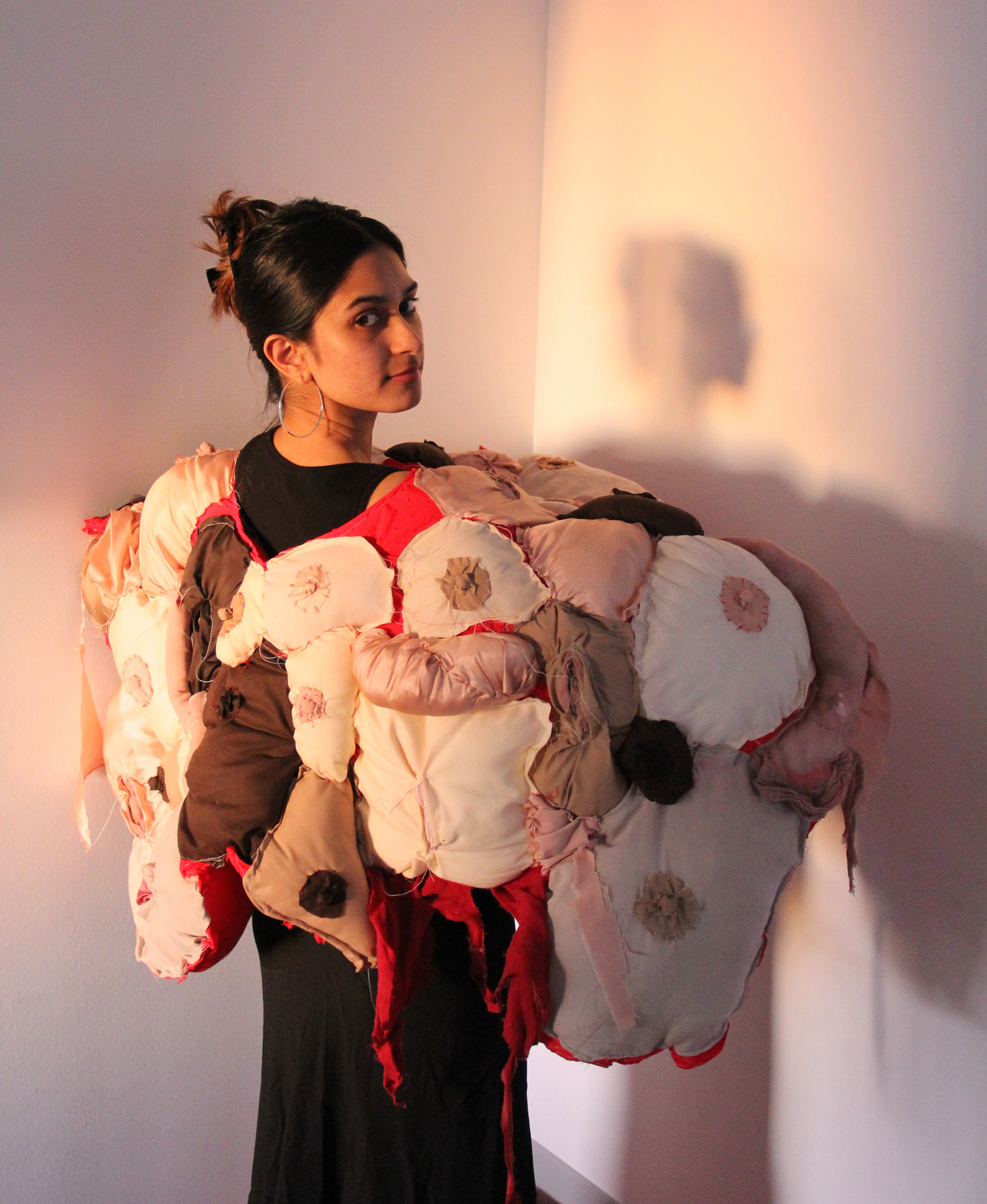 This work was inspired by my research into feminist artists, their work, and their subversions of the male gaze. I wanted to incorporate these explorations of the tender self, vulnerable femininity and attention grabbing imagery into my concept, resulting in this tactile, sculptural cloak of female flesh and genitalia. The discomfort comforts the wearer and the comfort discomforts the viewer. Womanhood is not always going to be beautiful, and perhaps it will even be uncomfortable, but it will always be here, existing in all its raw reality. 