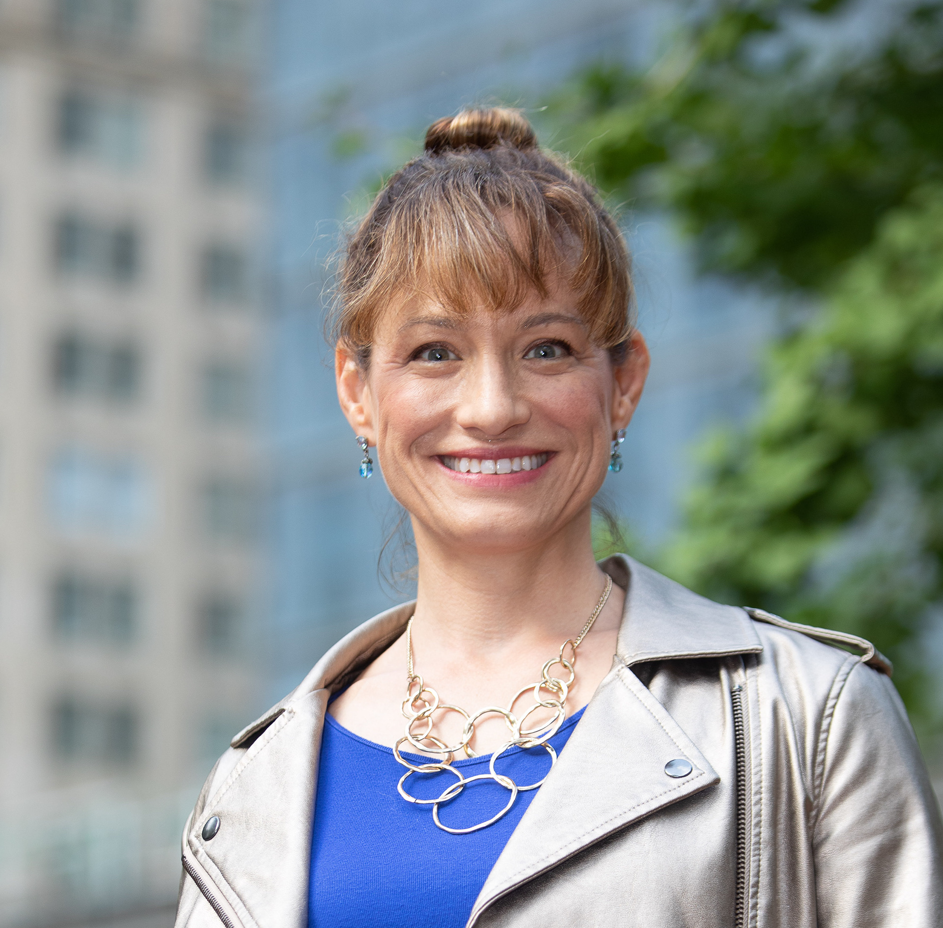 Portrait of Lisa Smiling in front of a Leafy City scape