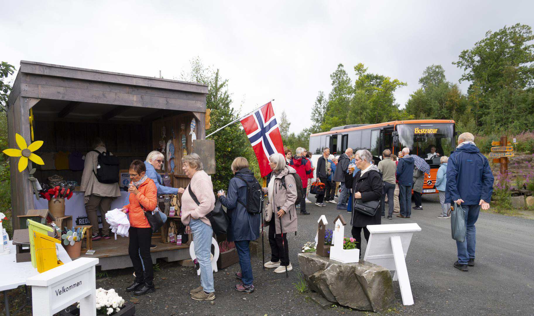 Besøk av ei gruppe. I denne bua har Karolines Redesign utsal på fine dagar. Dette er ei av dei 9 buene på GULLHAUG, som kan flyttast rundt med truck. Foto Atle Helland.