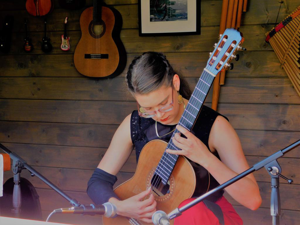 Intimkonsert i kapellet, med veggen skyvd til side, og publikum på benker ute. Her med amerikanske Veronica på gitar.