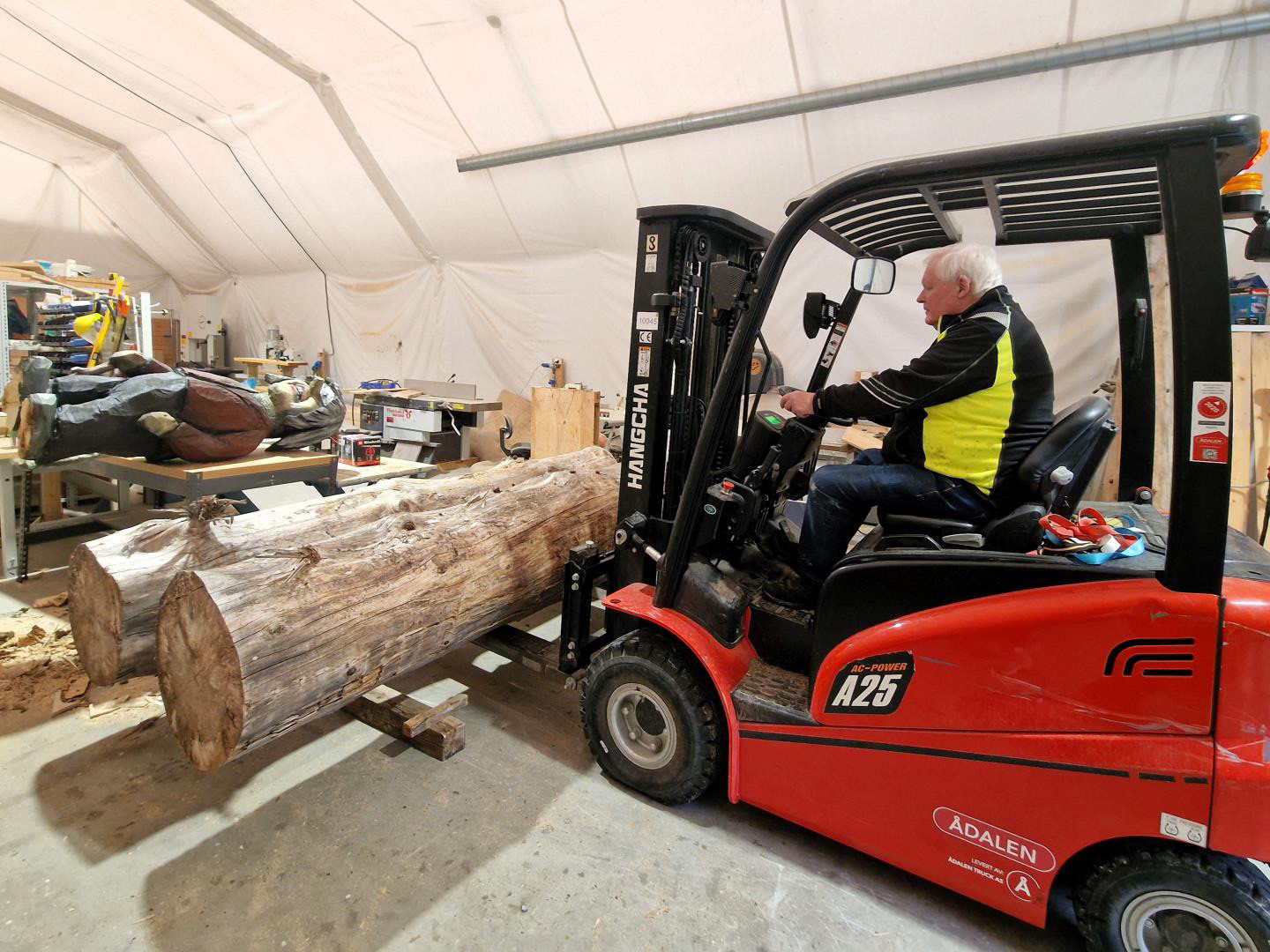 Trucken handterer store stokkar, som gjerne kan bli til ein gubbe, tilsvarande den som ligg på bordet til venstre.