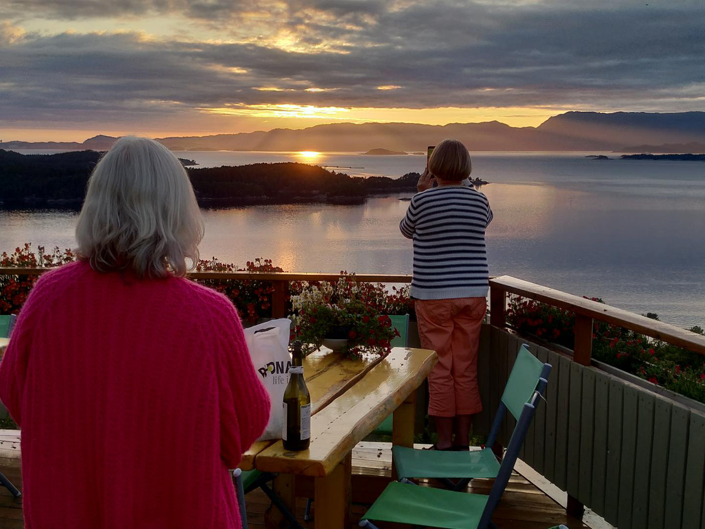 Anna tek bilde av solnedgangen på GULLHAUG, mens ei nabokone ser på.