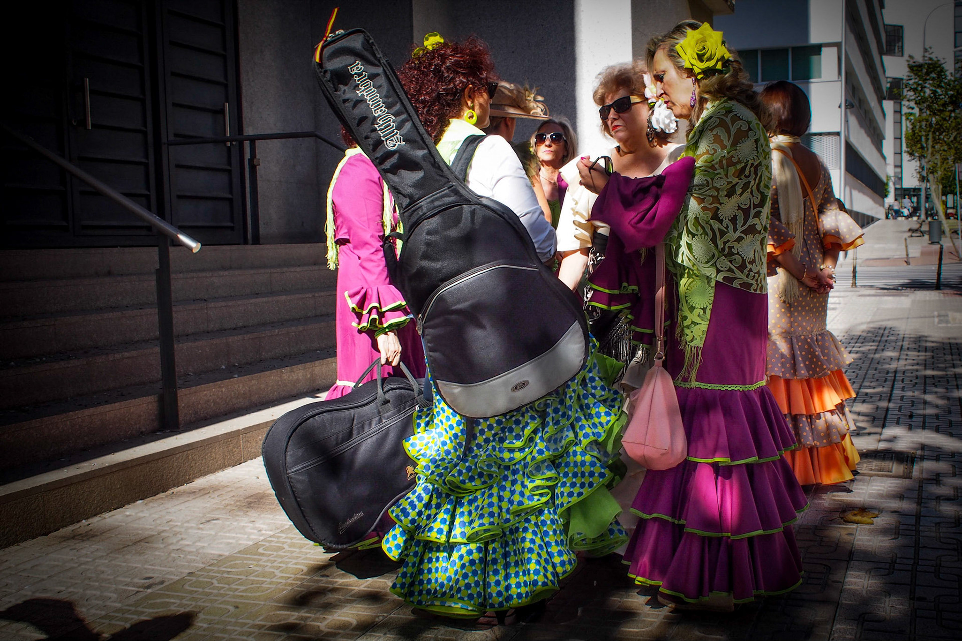 A group of flamenco women with guitars stop for a chat in the street in Almeria City, Spain.