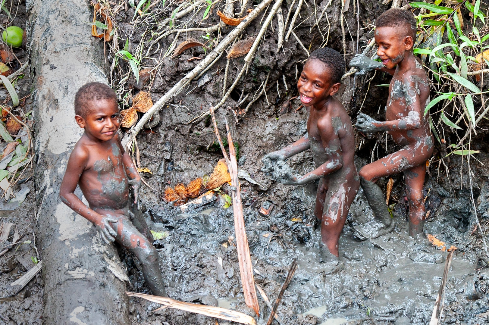 Enfants Asmat en train de jouer dans la boue