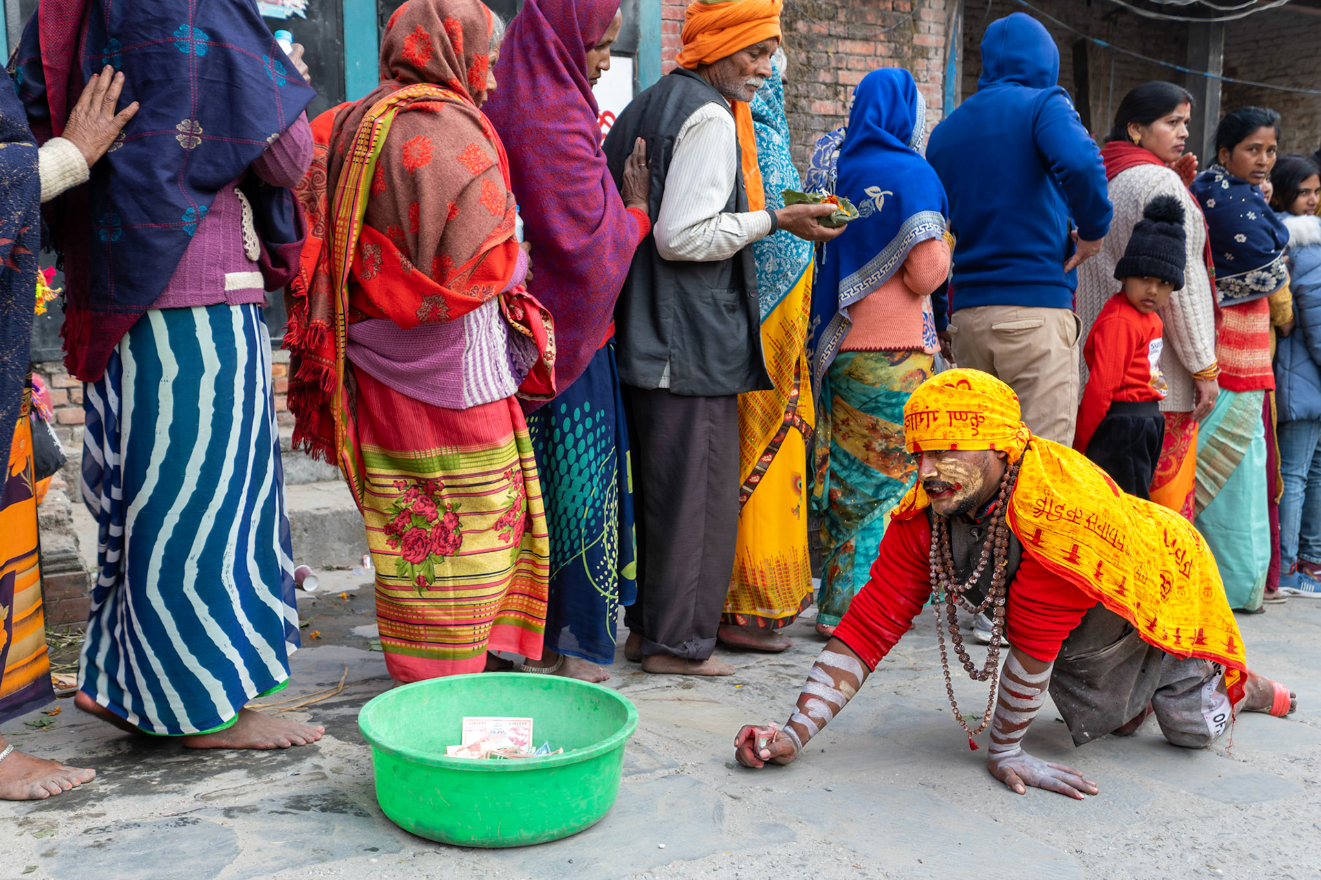 Dès le matin tôt, une queue interminable s'est formée afin d'entrer dans le temple. Ce sont des kilomètres de queue qui sont figés sur les trottoirs, à l'extérieure de l'enceinte. Des milliers de fidèles sont venus d'Inde pour participer à ce festival unique. Un Sadhu fait l'aumône en rampant sur le sol au pied des pèlerins