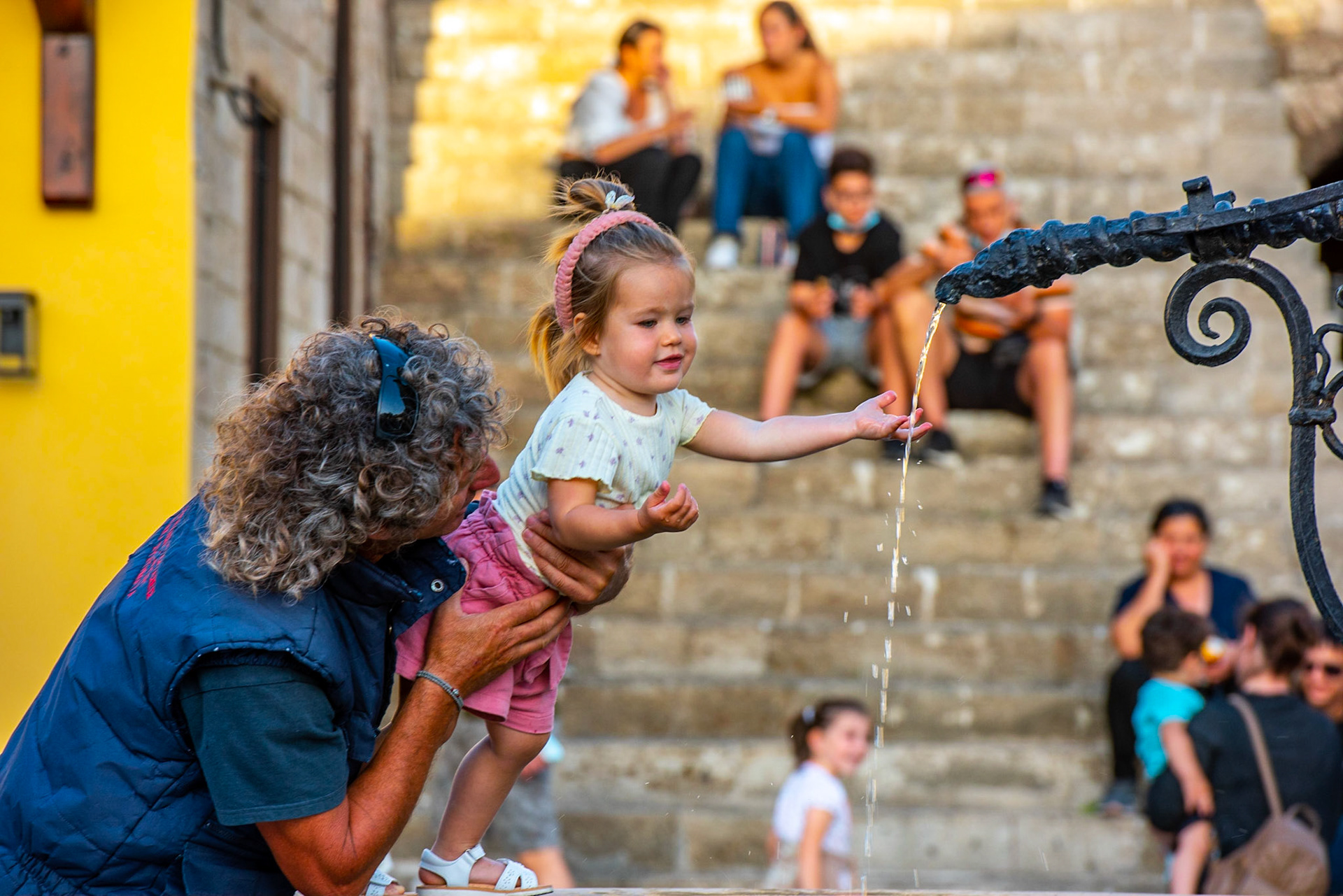 Enfant se rafraichissant à une fontaine dans la ville de Rhodes désertée par la touristes en plein COVID