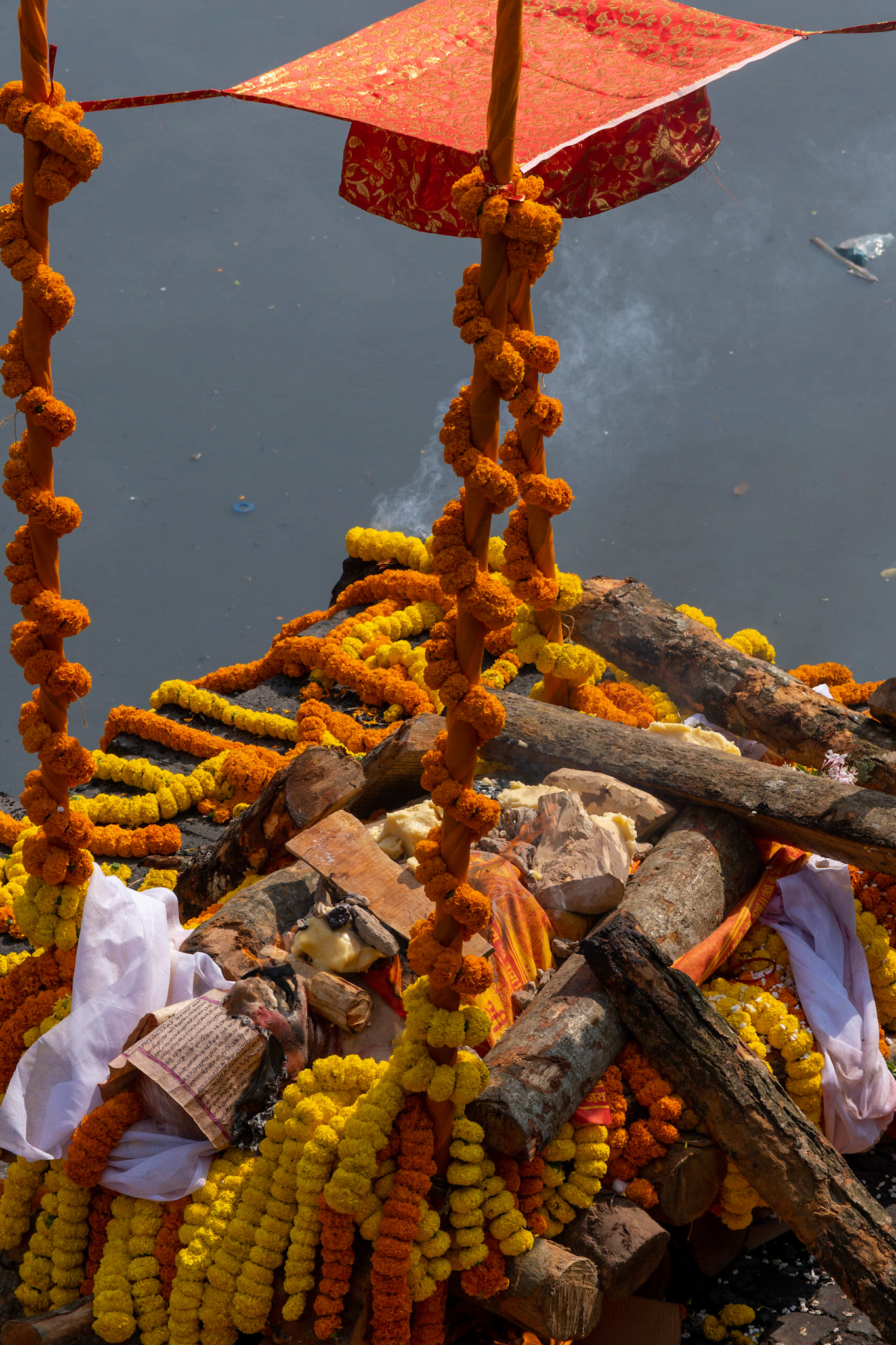 La veille dame a traversé le pont. Elle a été installée avec précaution sur ce bûchet joliment fleuri. Une feuille de papier a été posée sur son visage, c'est là que le feu a été allumé. Là encore, les crémations se déroulent devant une foule énorme, surtout en ce jour de Shivaratri. Dans l'hindouisme, la crémation libère le corps de l'âme qui peut alors accéder à un niveau supérieur.
