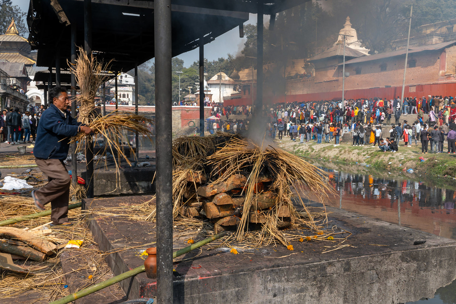 Le long de la rivière, les bûchets crachent leur fumée noire devant des milliers de gens et dans l'indifférence générale.