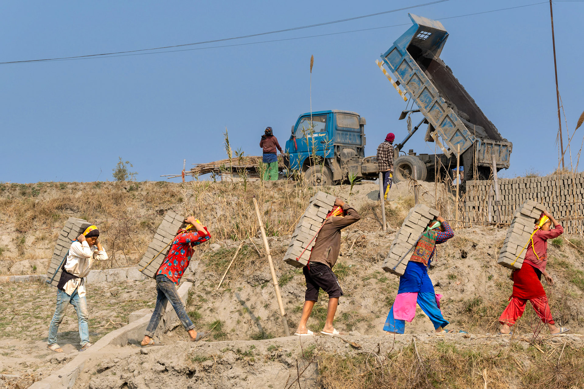 Il faut parfois parcourir 1 km afin de porter son fardeau au four où les briques seront cuites. Les briques sont posées sur un petit cadre métallique auquel on a attaché une ficelle qu'on passe sur le front. Il faut de l'expérience pour porter 50 kg de briques sans en faire tomber une seule, d'autant que certains courent tout ou partie du chemin. Car là encore, ils sont payés au volume de briques transportées.